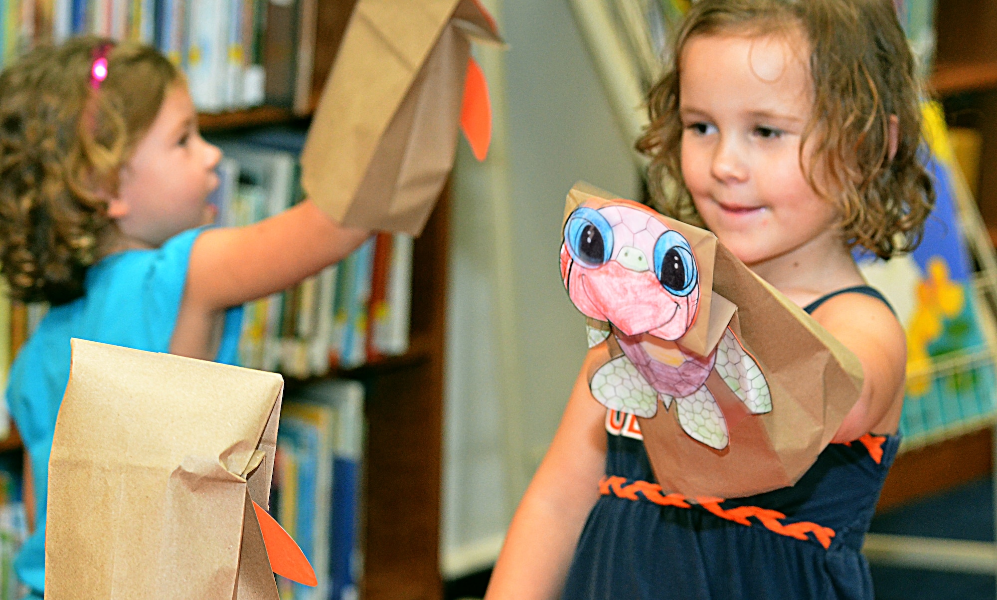 A child plays with a puppet she made during story time at the base library Aug. 7, 2013, on Andersen Air Force Base, Guam. Every story time begins with singing a song, followed by the story, finishing with the related activity. Story time is held every Wednesday from 3 to 4 p.m. at the Andersen Library. For more information, call 366-4291. (U.S. Air Force photo by Airman 1st Class Mariah Haddenham/Released)