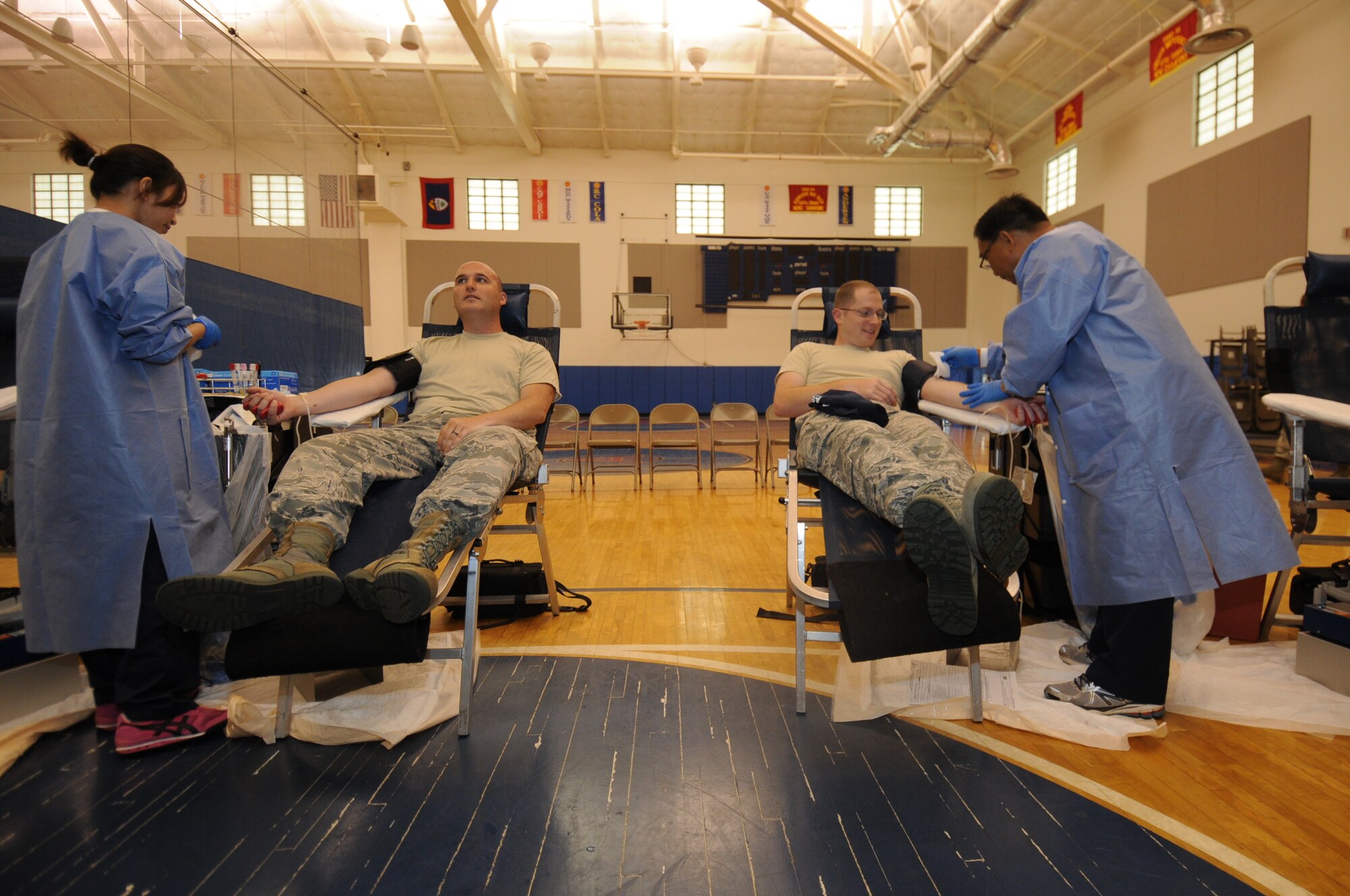 Staff Sgt. Kenneth Coppernoll, 734th Air Mobility Squadron aerial port training manager, and Staff Sgt. Nicholas Taves, 734th AMS maintenance training manager, donate blood to the Armed Services Blood Program Aug. 7, 2013, on Andersen Air Force Base, Guam. Donors give approximately one pint of blood, which is 10 percent of the blood in an adult body. (U.S. Air Force photo by Airman 1st Class Emily A. Bradley/Released)