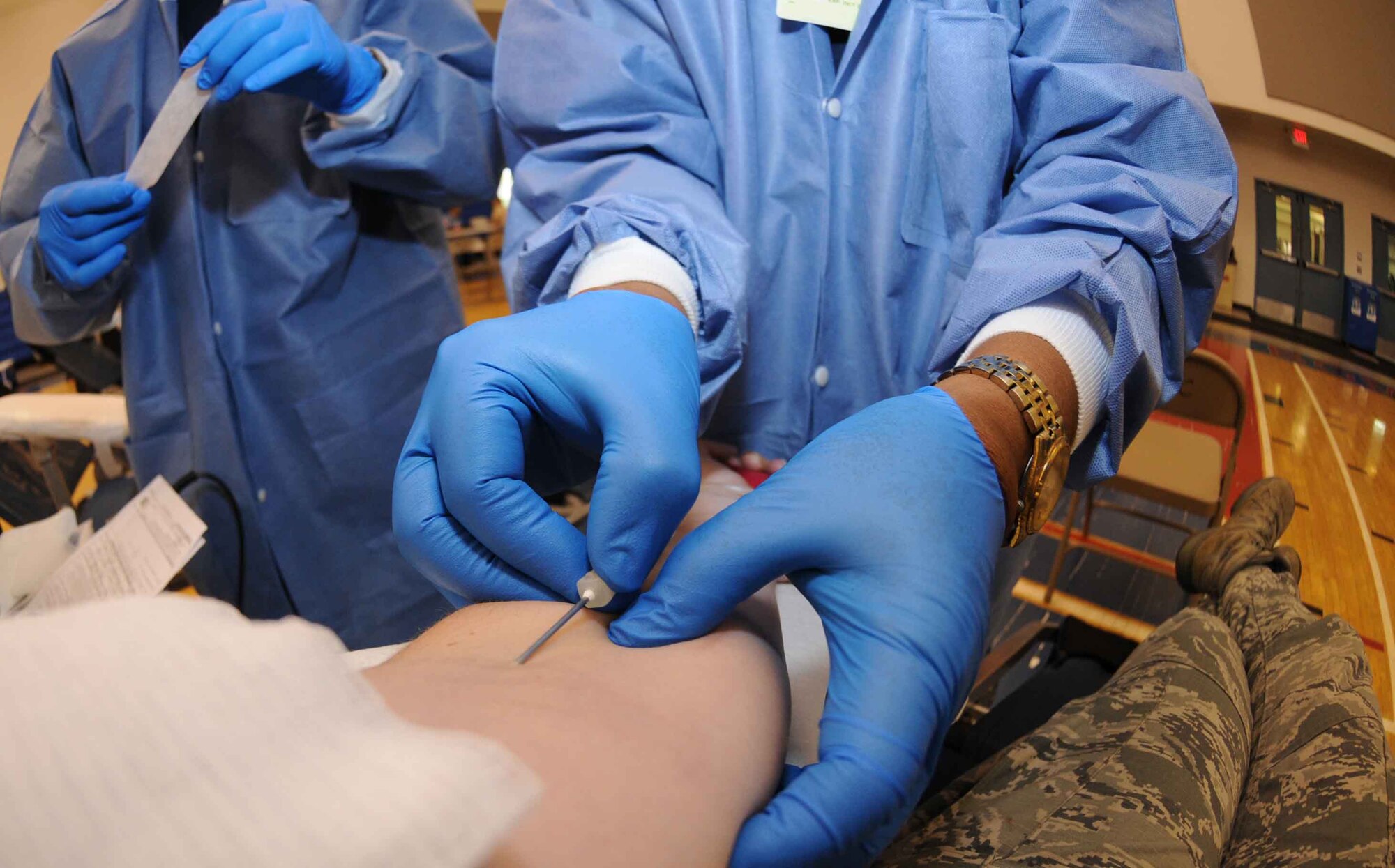 Badio Patague, U.S. Naval Hospital Guam phlebotomist, inserts a 17-gauge needle into a patient’s arm during an Armed Services Blood Program blood drive Aug. 7, 2013, on Andersen Air Force Base, Guam. Blood is typically drawn from median cubital veins, which are closest to the skin on the inside of the elbow. (U.S. Air Force photo by Airman 1st Class Emily A. Bradley/Released)
