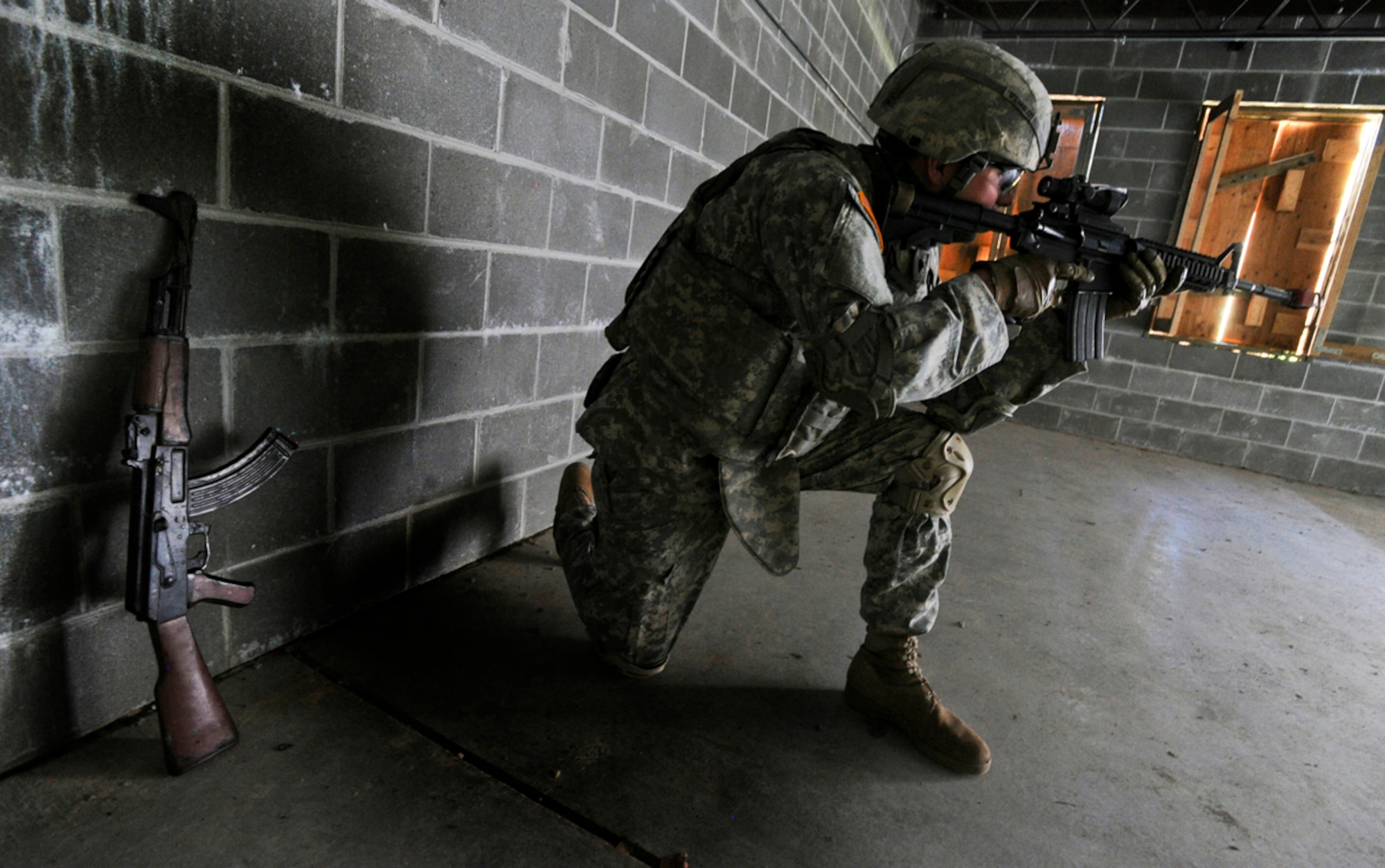 JOINT BASE ELMENDORF-RICHARDSON, Alaska -- Spc. Greg Hadley, assigned to the 164th Military Police Company, 2d Engineer Brigade, a native of Leesburg, Ga., covers a doorway in buiding on a situational training exercise lane during team qualifications at Joint Base Elmendorf-Richardson, Wednesday, July 24, 2013.  The military police Soldiers trained on various team-based scenarios aimed at testing their abilities to adapt to rapidly changing situations under stressful physical and mental conditions.   (U.S. Air Force photo/Justin Connaher)