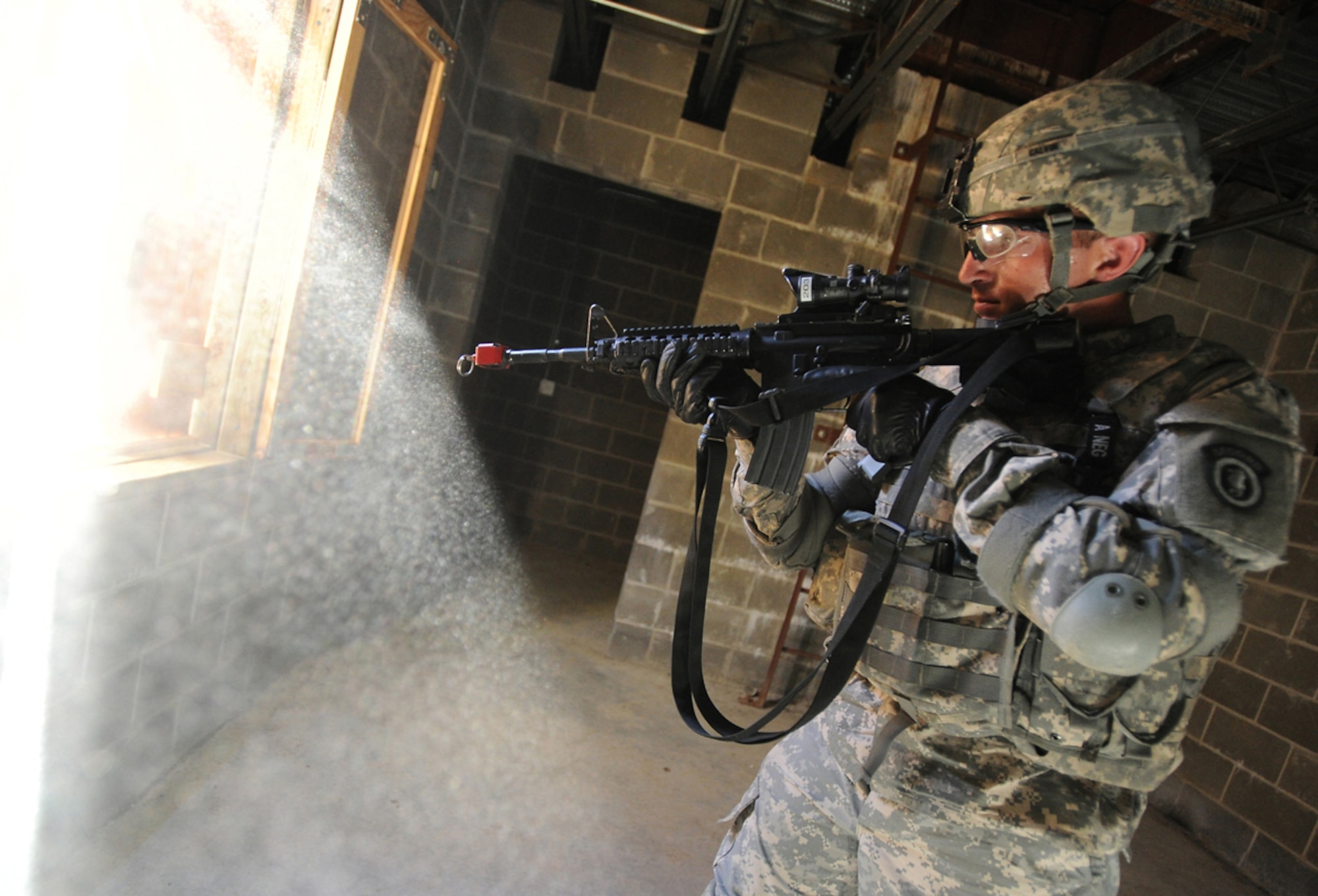 JOINT BASE ELMENDORF-RICHARDSON, Alaska -- Army Pfc. Jeremy Calvin, assigned to the 164th Military Police Company, 2d Engineer Brigade, a native of El Paso, Texas, covers a window in a building on a situational training exercise lane during team qualifications at Joint Base Elmendorf-Richardson, Wednesday, July 24, 2013.  The military police Soldiers trained on various team-based scenarios aimed at testing their abilities to adapt to rapidly changing situations under stressful physical and mental conditions.   (U.S. Air Force photo/Justin Connaher)
