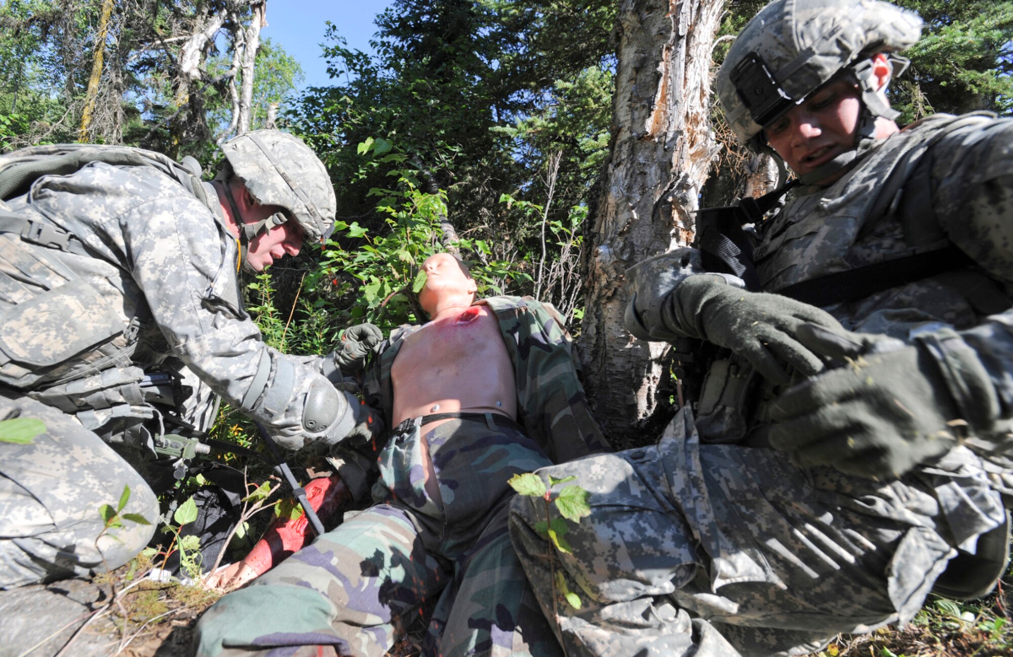 JOINT BASE ELMENDORF-RICHARDSON, Alaska -- Army Sgt. Matthew Ramage, a native of Cleveland, Ohio, left, and Army Pfc. Eric Leow, a native of Laingsburg, Mich., both assigned to the 164th Military Police Company, 2d Engineer Brigade, provide first aid to a simulated casualty in a situational training exercise lane during team qualifications at Joint Base Elmendorf-Richardson, Wednesday, July 24, 2013.  The military police Soldiers trained on various team-based scenarios aimed at testing their abilities to adapt to rapidly changing situations under stressful physical and mental conditions.   (U.S. Air Force photo/Justin Connaher)