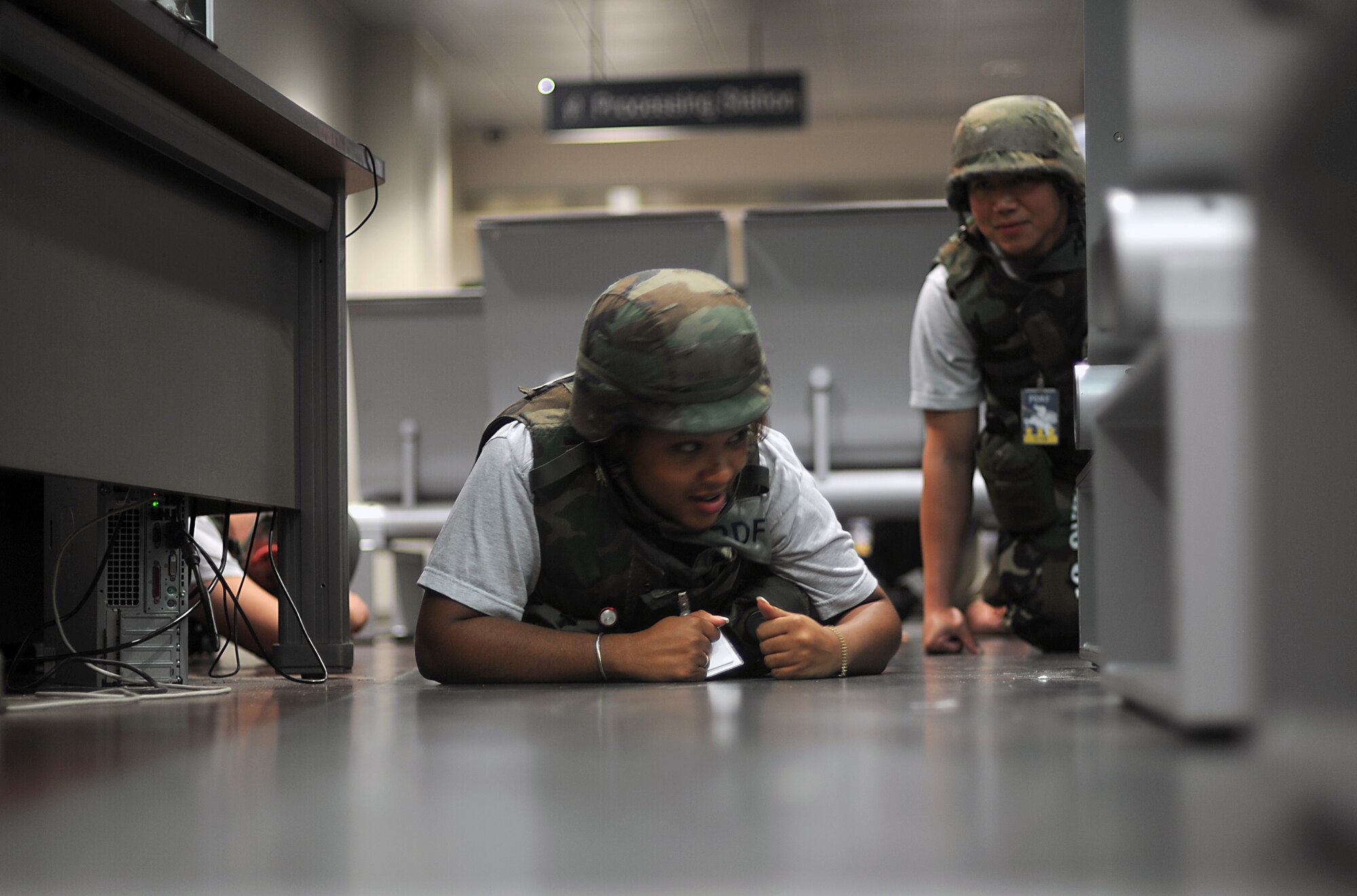 Senior Airmen Allanna James, 51st Force Support Squadron, takes cover as a simulated missile hits the base during Operational Readiness Exercise Beverly Midnight 13-03, Aug. 8, 2013. Throughout the week-long exercise, Osan Airmen were tested on their ability to incorporate their chemical, biological, radiological and nuclear training into their daily operations. (U.S. Air Force photo/Staff Sgt. Sara Csurilla)  
