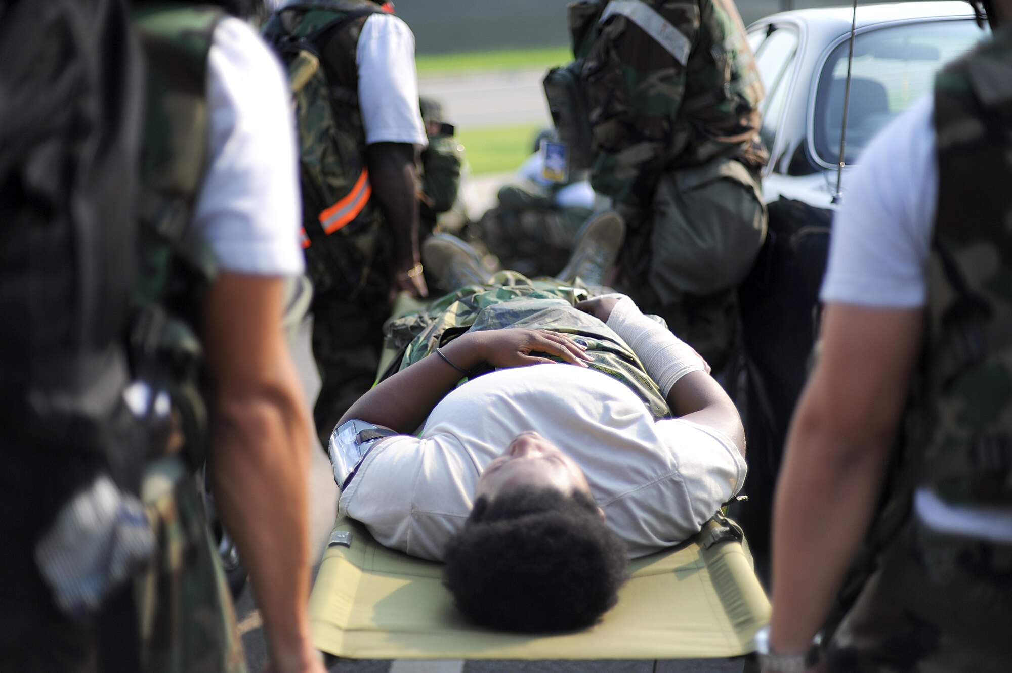 Members of the 731st Air Mobility Squadron carry a patient on a stretcher after treating her simulated wounds during Operational Readiness Exercise Beverly Midnight 13-03, Aug. 8, 2013. Throughout the week-long exercise, Airmen experienced a number of wartime scenarios to test their knowledge and capabilities to fight through chemical and mortar attacks, opposing forces trying to breach the base, and administer self-aid and buddy care. This is Osan’s fourth simulated wartime contingency exercise in 2013. (U.S. Air Force photo/Staff Sgt. Sara Csurilla) 
