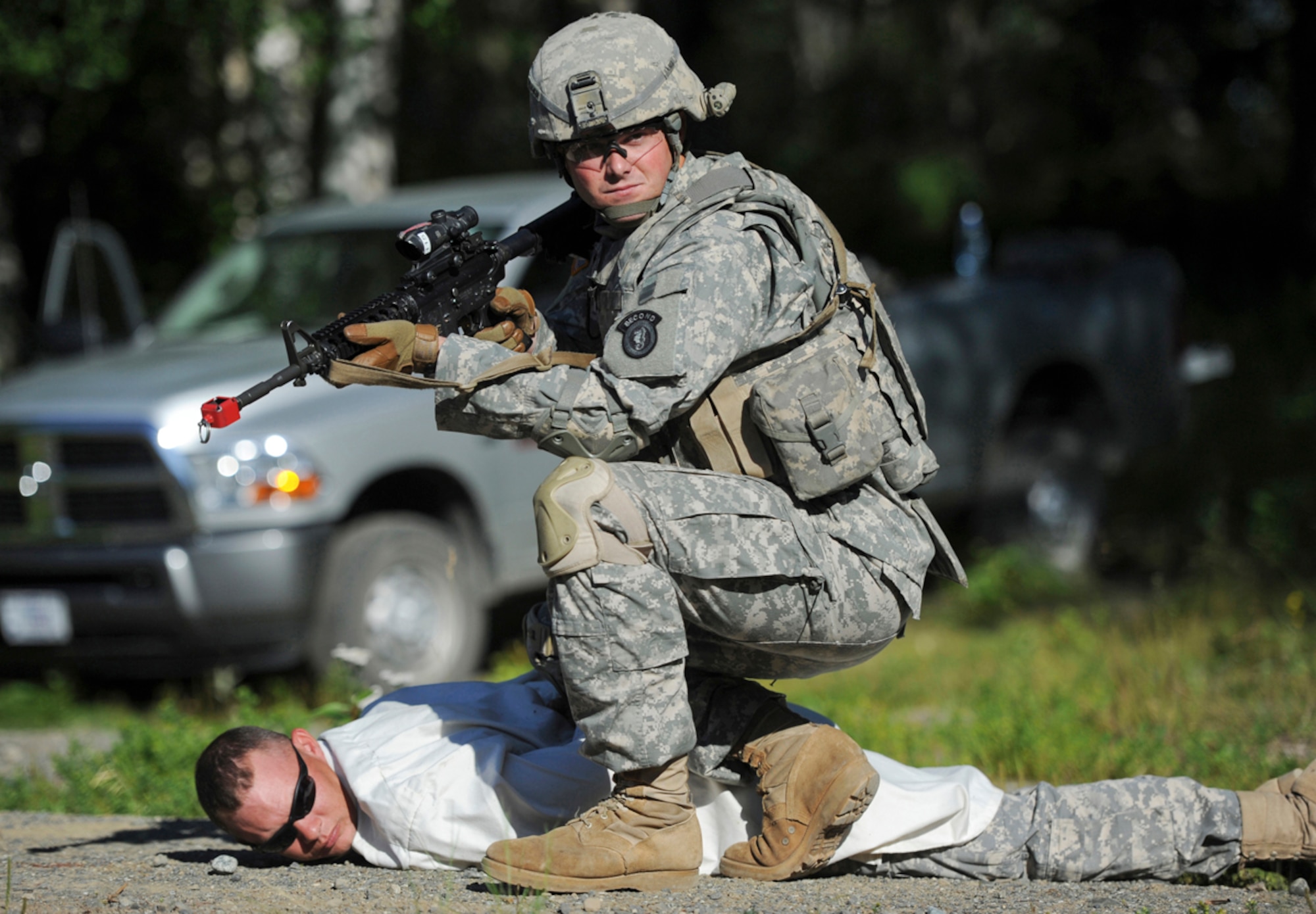 JOINT BASE ELMENDORF-RICHARDSON, Alaska -- Spc. Greg Hadley, assigned to the 164th Military Police Company, 2d Engineer Brigade, a native of Leesburg, Ga., guards a detainee on a situational training exercise lanes during team qualifications at Joint Base Elmendorf-Richardson, Wednesday, July 24, 2013.  The military police Soldiers trained on various team-based scenarios aimed at testing their abilities to adapt to rapidly changing situations under stressful physical and mental conditions.   (U.S. Air Force photo/Justin Connaher)