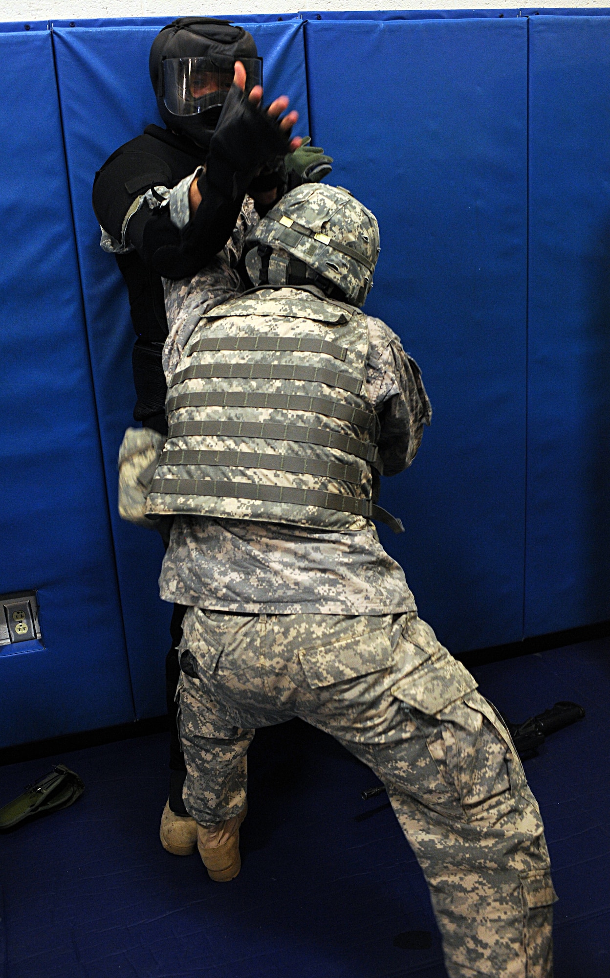 U.S. Army Staff Sgt. Kelly Greenidge pins Capt. Matthew Booth, 1st Battlefield Coordination Detachment, against a wall during the U.S. Army Basic Combatives Course at Davis-Monthan Air Force Base, Ariz., July 25, 2013. Participants in the course learned basic hand-to-hand combat techniques that could be used to disable combatants should the need arise. (U.S. Air Force photo by Senior Airman Timothy Moore/Released)