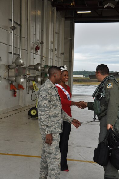 Gwynne James introduces herself to Maj. Chad Newkirk, 302nd Fighter Squadron F-22 pilot before his flight here August 8. Gwynne, who took first place in the Mrs. Alaska pageant, and her husband Airman 1st Class Jermaine James, 477th Aircraft Maintenance Squadron crew chief launched Newkirk out on his sortie. (U.S. Air Force/Tech. Sgt. Dana Rosso)