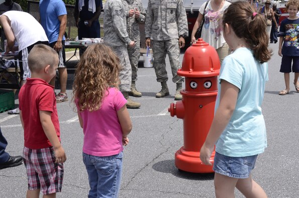 Visitors interact with Pluggie, Dobbins Fire Department mascot, during the 94th Airlift Wing Family Day at the Dobbins Lakeside Facility Aug. 4. (U.S. Air Force photo/Don Peek)