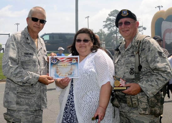 Col. Tim Tarchick, 94th Airlift Wing commander, presents Lauren M. Oswald, wing security specialist and wife of Staff Sgt. Charles Oswald, 94th Security Forces specialist, with a Certificate of Congratulations for being the 94th AW 2013 Spouse of the Year awardee during Wing Family Day Aug. 4. (U.S. Air Force photo/Don Peek)