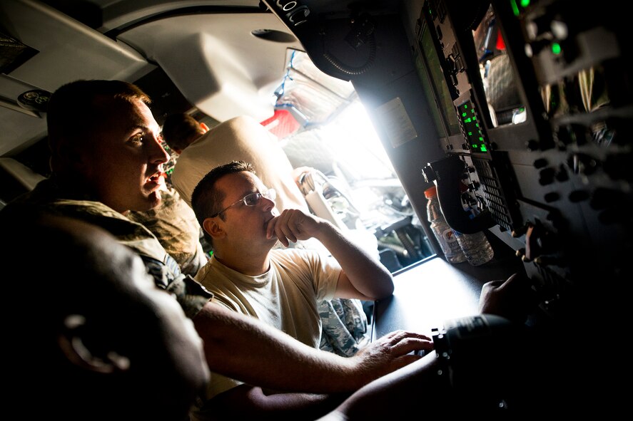 U.S. Air Force Staff Sgt. Charles Woods, 372nd Training Squadron Detachment 9 electronic warfare instructor, demonstrates functions of an HC-130J communications navigation identification-management unit to Staff Sgts. Avaris Murray (bottom left) and Ronald Kearse during a field training detachment class at Moody Air Force Base, Ga., July 30, 2013. Murray and Kearse are both electronic warfare craftsmen with the 723d Aircraft Maintenance Squadron. (U.S. Air Force photo by Staff Sgt. Jamal D. Sutter/Released) 