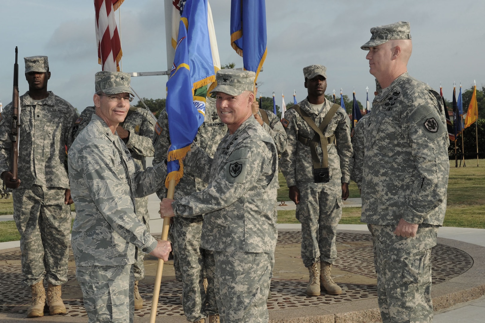 Brig. Gen. Bob LaBrutta (left), commander of the 502nd Air Base Wing and Joint Base San Antonio, passes the 502nd Mission Support Group colors to incoming 502nd MSG commander Col. Steven A. Toft, as outgoing commander Col. John P. Lamoureux (right) looks on. Lamoureux is leaving the 502nd MSG to become commander of the Dwight D. Eisenhower Army Medical Center at Fort Gordon, Ga. (Photo by Mike O'Rear, JBSA-Fort Sam Houston Visual Information)