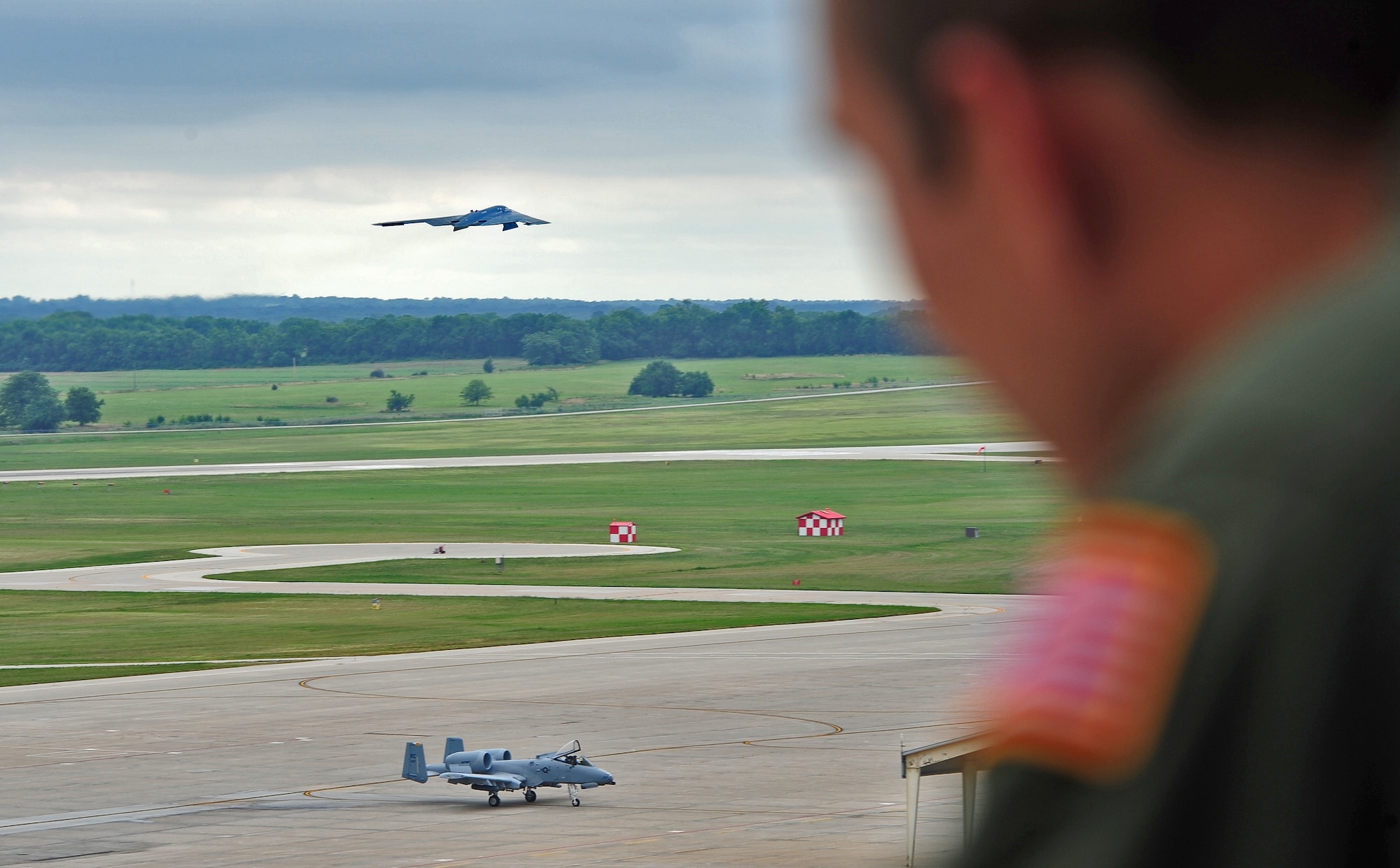 Cadet Ronald Moberg, a U.S. Air Force Academy junior student, watches as a B-2 Spirit lifts off of the runway at Whiteman Air Force Base, Mo., July 30, 2013. Moberg and several other cadets visited the base as part of Operation Air Force, a program that randomly assigns cadets to an Air Force base for three to six weeks. In an effort to spark interest in one or more career options, cadets shadow different squadrons to get exposure to various career fields. (U.S. Air Force photo by Staff Sgt. Nick Wilson/Released)