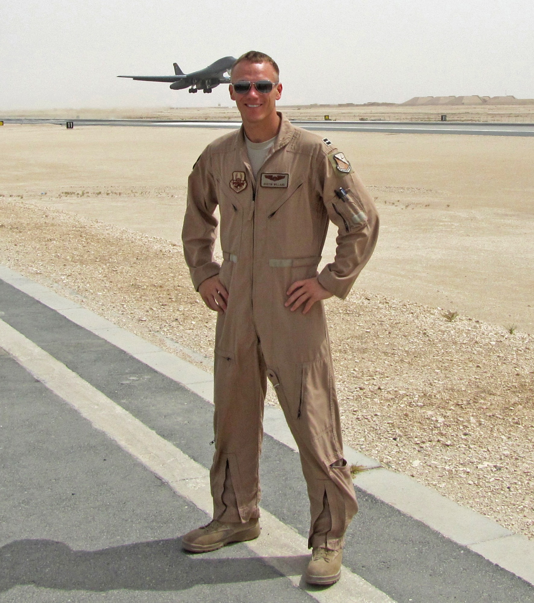 U.S. Air Force Capt. Dustin Willard poses for a photo on the flightline while a B-1 Bomber takes off in the background. Willard served as the aircraft commander of Bone-34, which was named the Air Force’s 2012 bomber crew of the year and was awarded with the Air Force Association’s Gen. Curtis E. LeMay Award. (Courtesy photo)