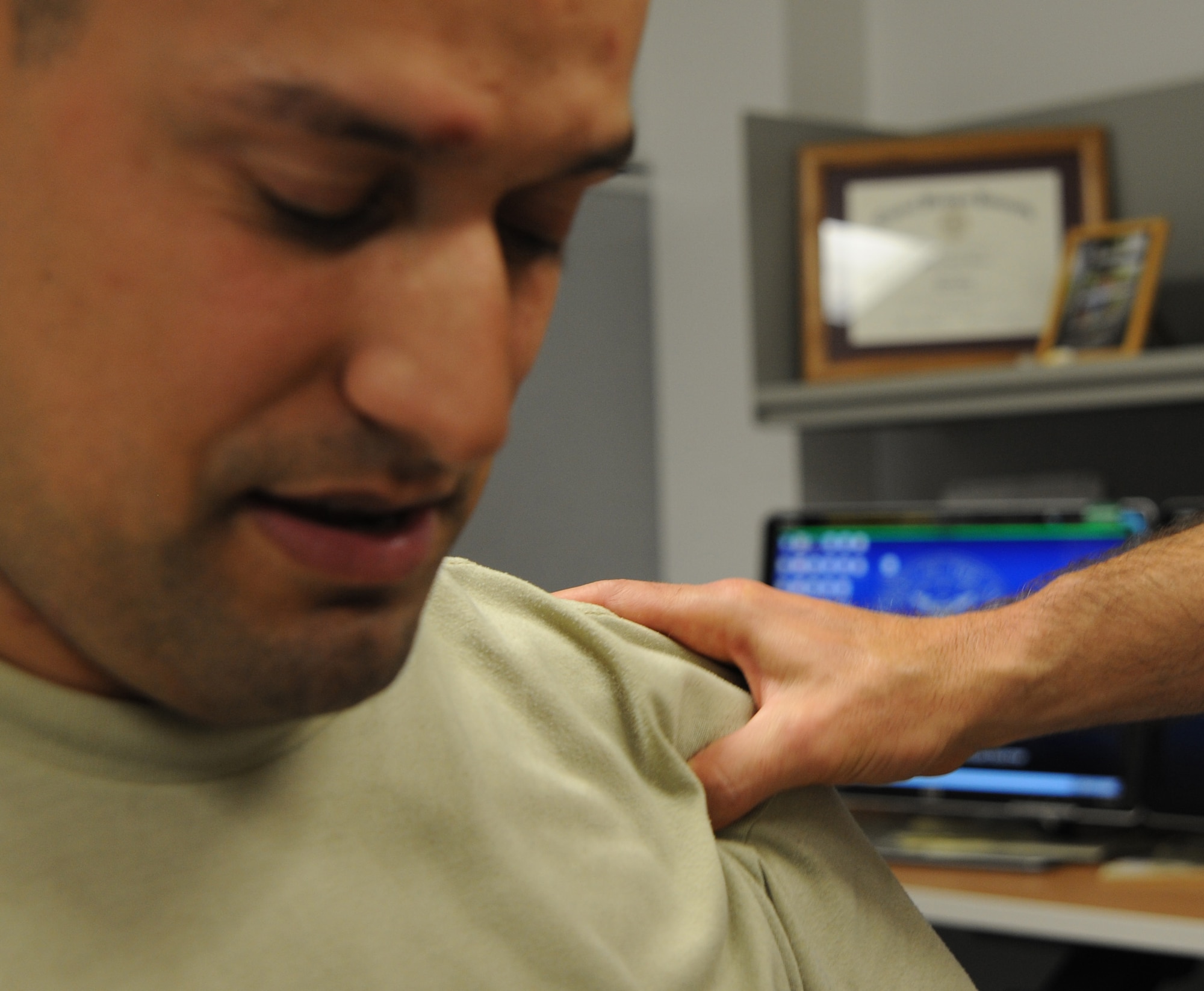 U.S. Air Force Maj. Michael Holmes, 509th Medical Operations Squadron physical therapy technician, puts pressure on the shoulder of U.S. Air Force Staff Sgt. Tim Ferguson, 509th Maintenance Group command chief assistant, to find the location of his injury at Whiteman Air Force Base, Mo., Aug. 6, 2013. The physical therapy clinic treats patients with small injuries such as minor sprains, all the way up to major injuries such as post-operation surgery on knees and shoulders. (U.S. Air Force photo by Airman 1st Class Bryan Crane/Released)