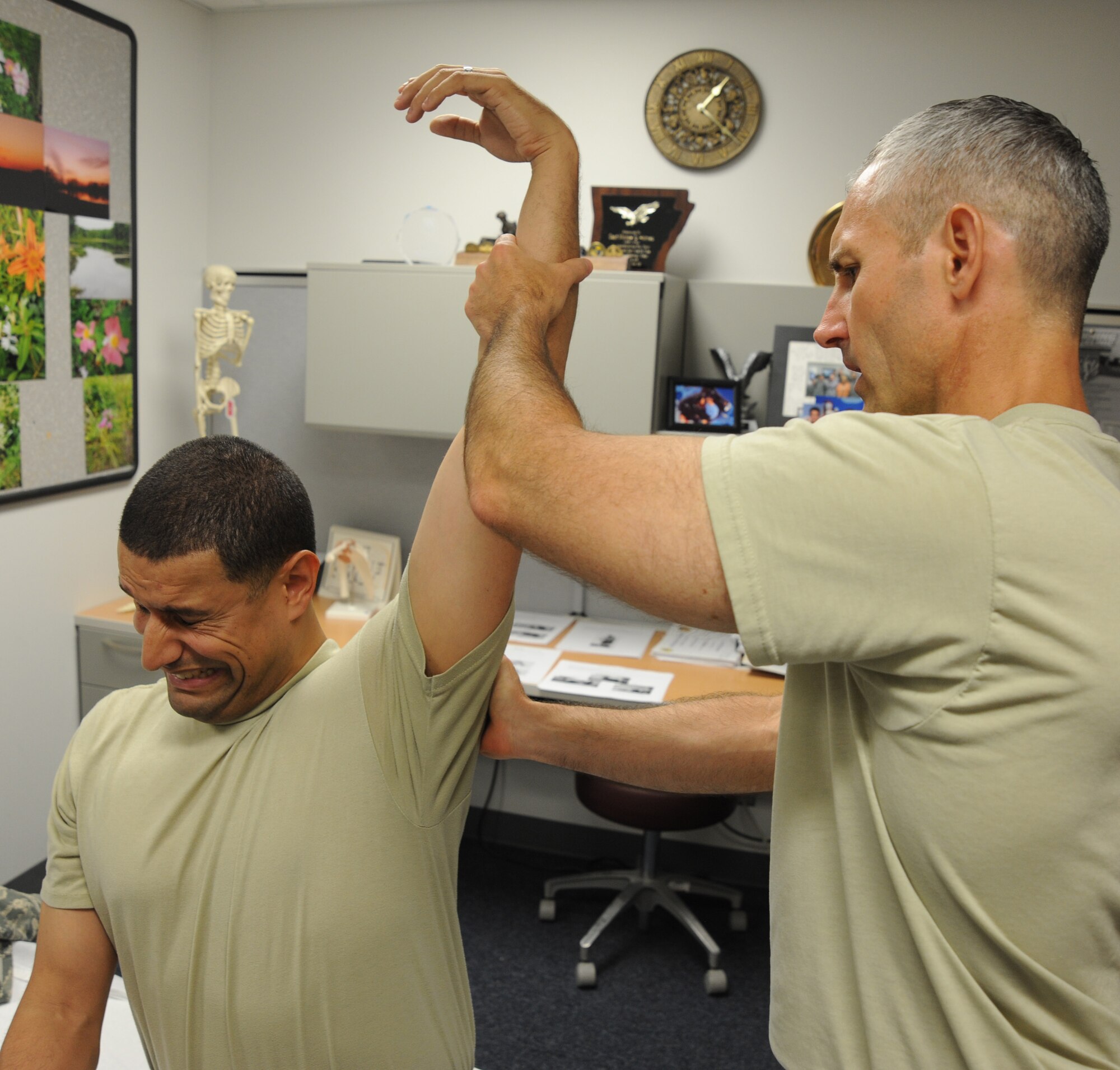 U.S. Air Force Maj. Michael Holmes, 509th Medical Operations Squadron physical therapy technician, stretches the shoulder of U.S. Air Force Staff Sgt. Tim Ferguson, 509th Maintenance Group command chief assistant, during an initial physical therapy evaluation at Whiteman Air Force Base, Mo., Aug. 6, 2013. The physical therapy clinic employs a variety of methods in providing evaluations, such as joint manipulation and mobilization, electrical stimulation, taping and bracing, and ultrasounds. (U.S. Air Force photo by Airman 1st Class Bryan Crane/Released)