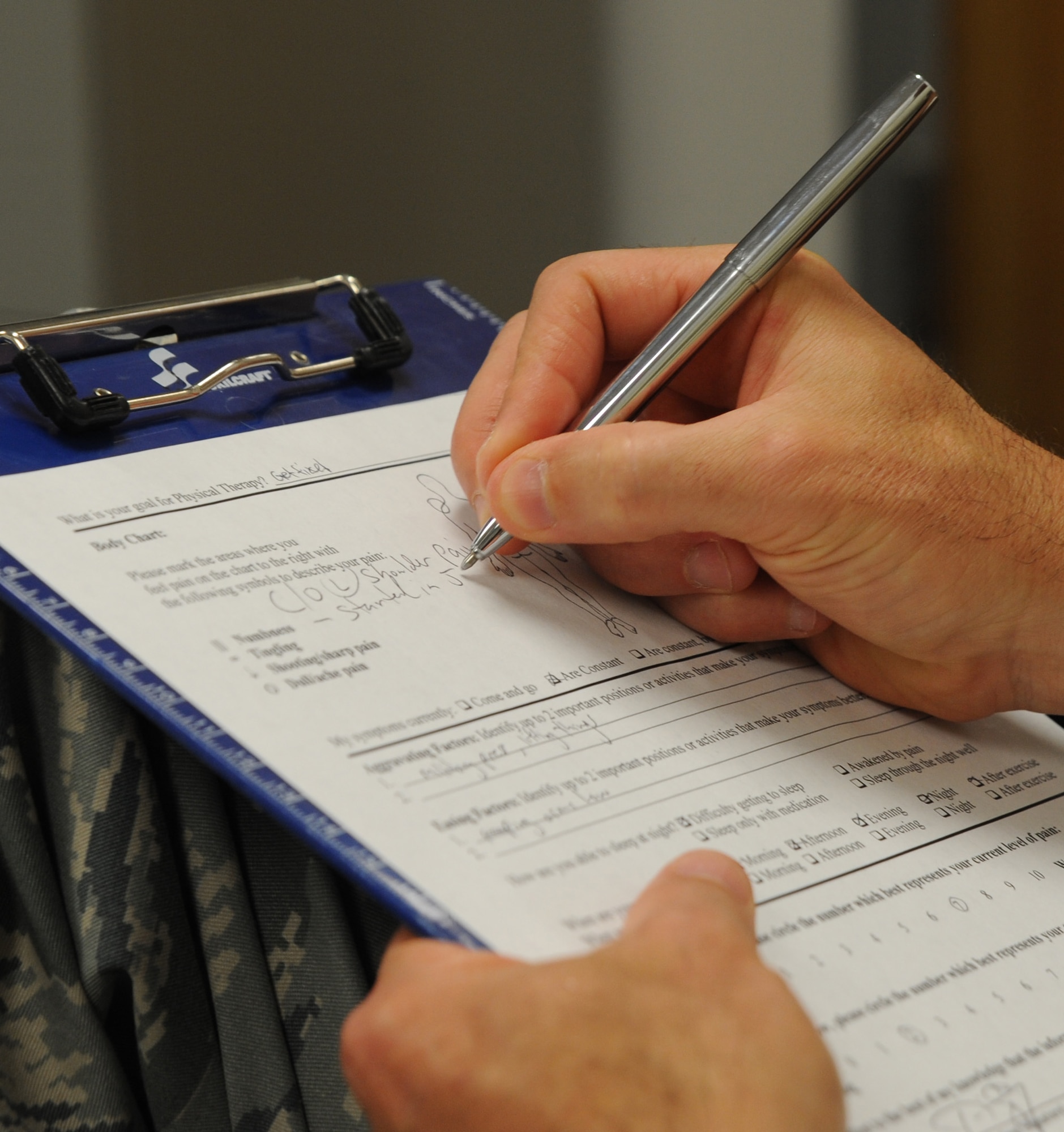 U.S. Air Force Maj. Michael Holmes, 509th Medical Operations Squadron physical therapy technician, writes an initial evaluation on a patient at Whiteman Air Force Base, Mo., Aug. 6, 2013. The physical therapy clinic provides evidence-based care for active-duty Airmen to expediently reduce pain and restore function following musculoskeletal injury or orthopedic surgery. (U.S. Air Force photo by Airman 1st Class Bryan Crane/Released)
