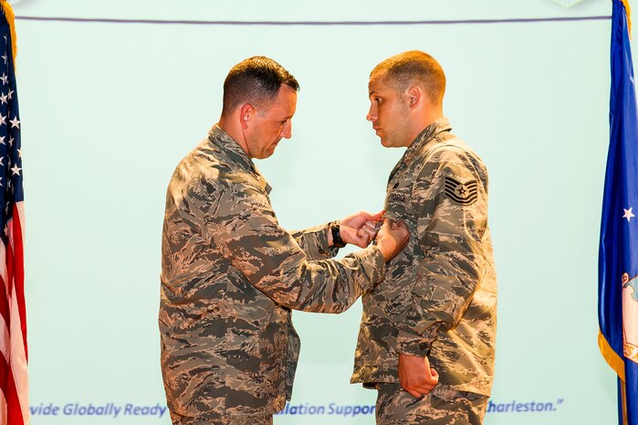 Col. Michael Mongold, 628th Mission Support Group commander, presents Tech. Sgt. Hartley, 628th Security Forces Squadron dog handler, with the Air Force Combat Action medal July 24, 2013, at Joint Base Charleston - Air Base, S.C. (U.S. Air Force photo/ Senior Airman George Goslin)