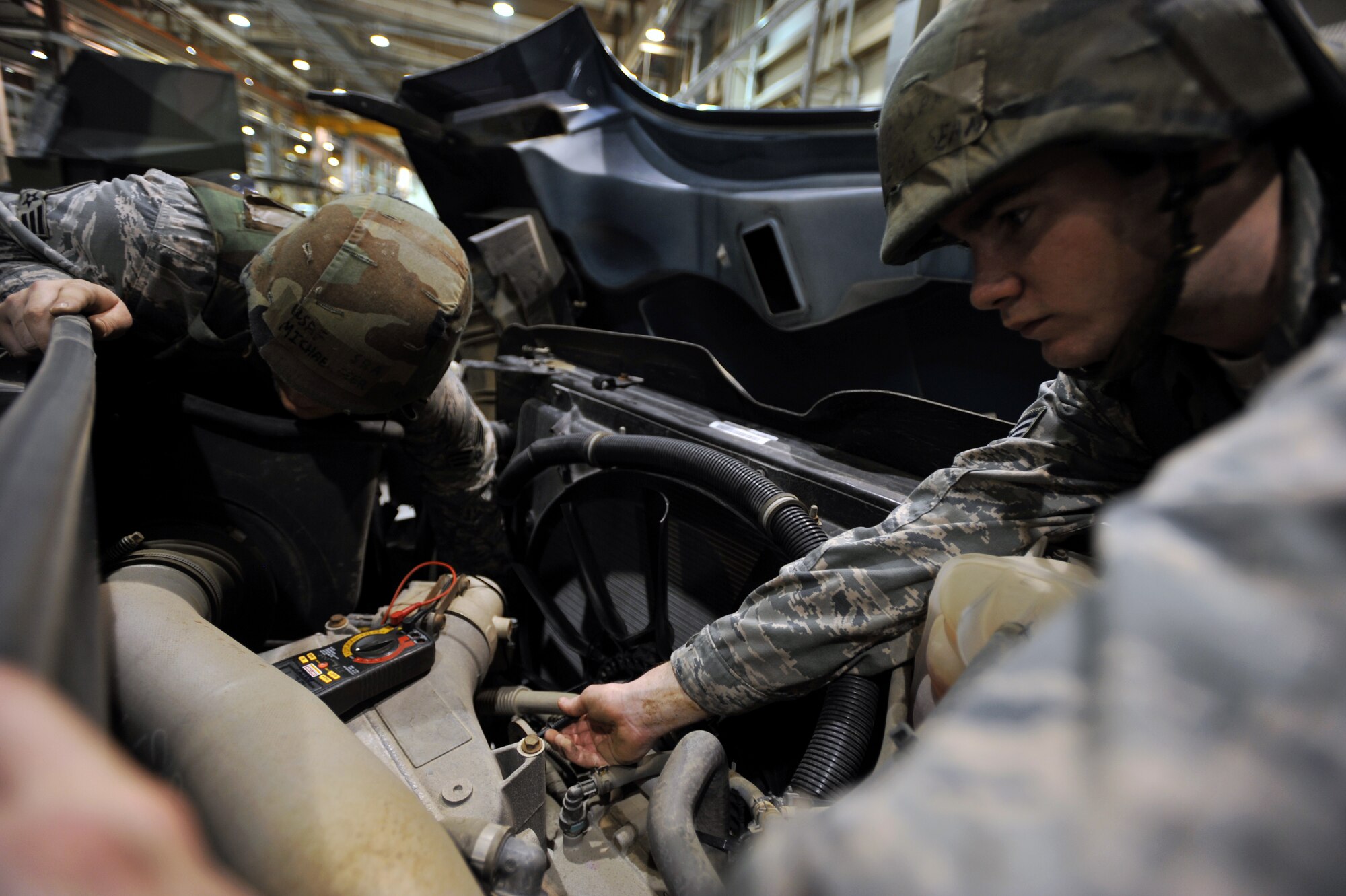 Senior Airmen Michael Geer and Sean Collins, 51st Logistics Readiness Squadron vehicle maintenance technicians, work on a vehicle’s alternator during Operational Readiness Exercise Beverly Midnight 13-03 at Osan Air Base, Republic of Korea, Aug. 9, 2013. OREs test Airmen’s ability to accomplish the mission under wartime conditions. (U.S. Air Force photo/Senior Airman Siuta B. Ika)