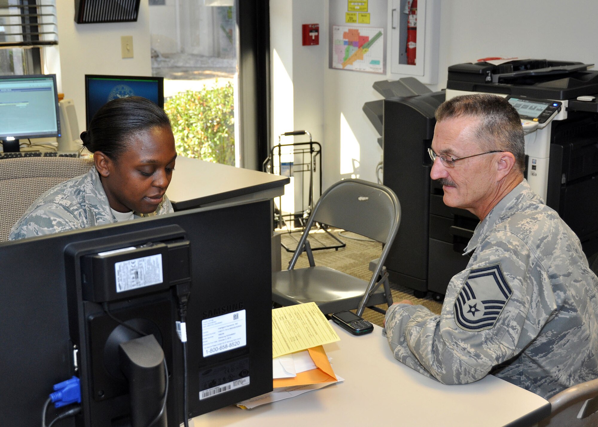TRAVIS AIR FORCE BASE, Calif. -- Senior Airman Shanice Jackson, a 349th Aerospace Medicine Squadron medical assistant, discusses the Fitness Clinic process with Senior Master Sgt. Howard Miller. The program requires members to bring in private medical documentation only during the Fitness Clinic hours, and not at any other times, to be seen without appointment. The Fitness Clinic takes place from 8 to 10 a.m., at the unit, every Saturday of the Unit Training Assembly weekends. (U.S. Air Force photo / Senior Airman Cindy Alejandrez) 