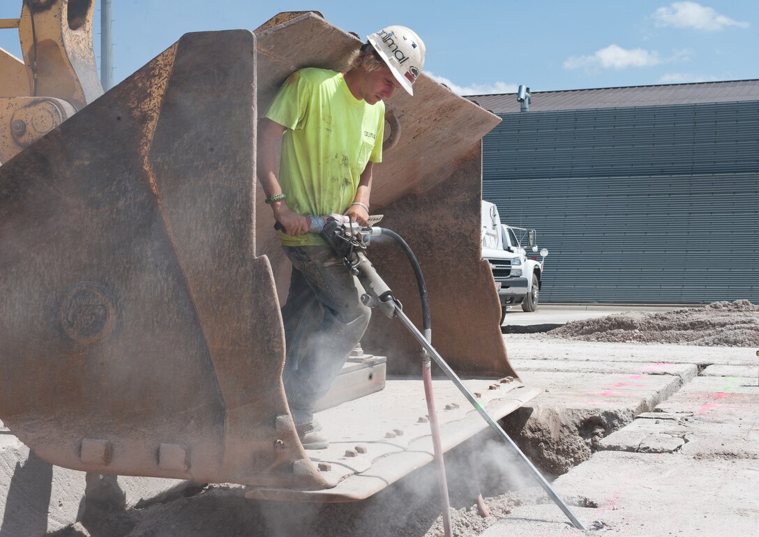 Josiah Herman, Quinn Construction employee, drills holes into concrete slabs to make it easier to remove the concrete during flightline reconstruction at Ellsworth Air Force Base, S.D., Aug. 5, 2013. The areas are cut into square slabs so they can be removed, allowing the team to pour new concrete. (U.S. Air Force photo by Airman 1st Class Alystria Maurer/Released)