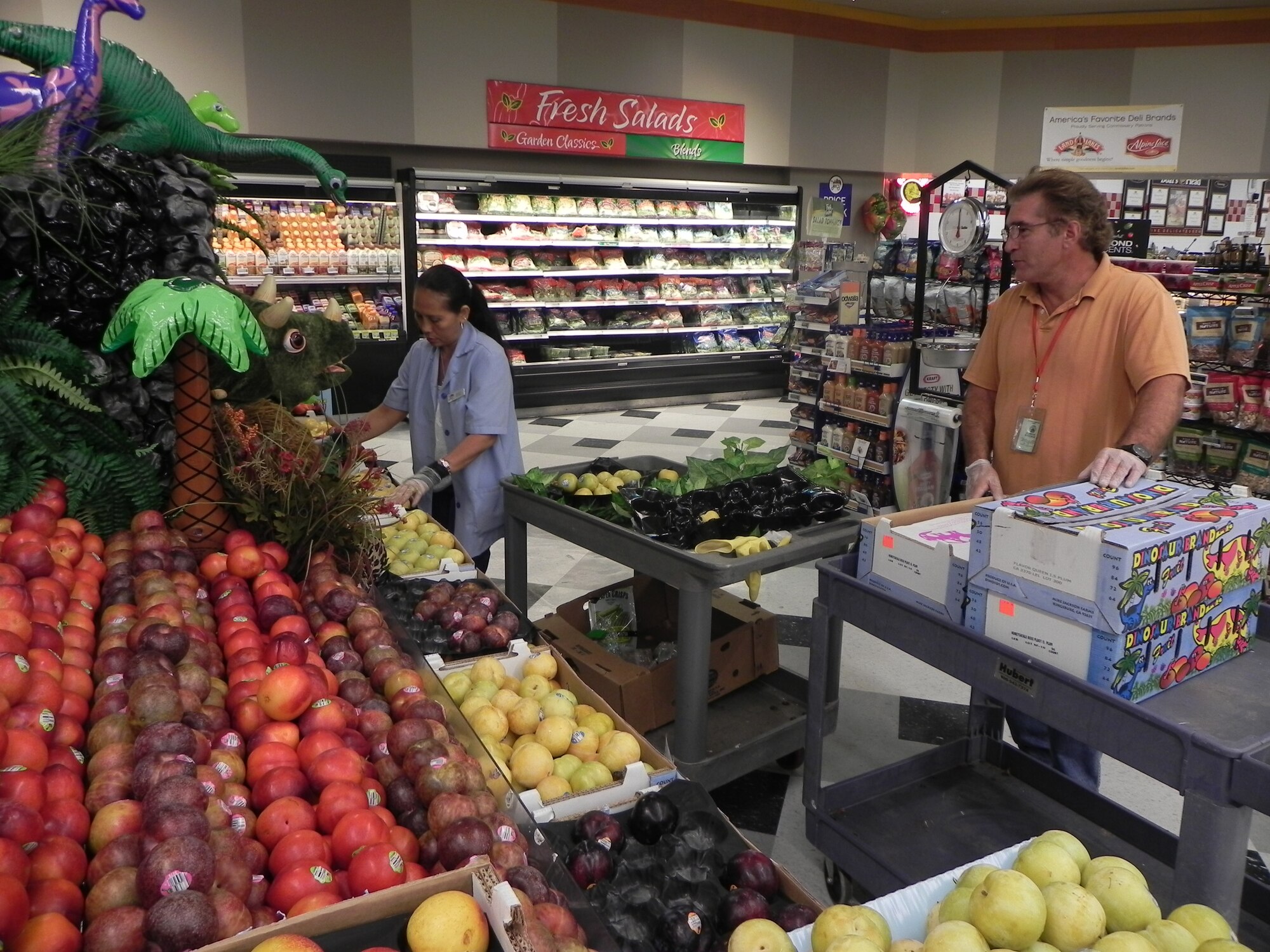 Store worker Jessica Vigo and vendor stocker Tim Dupre add fruit to a display in the Commissary at Patrick Air Force Base, Fla., August 8.