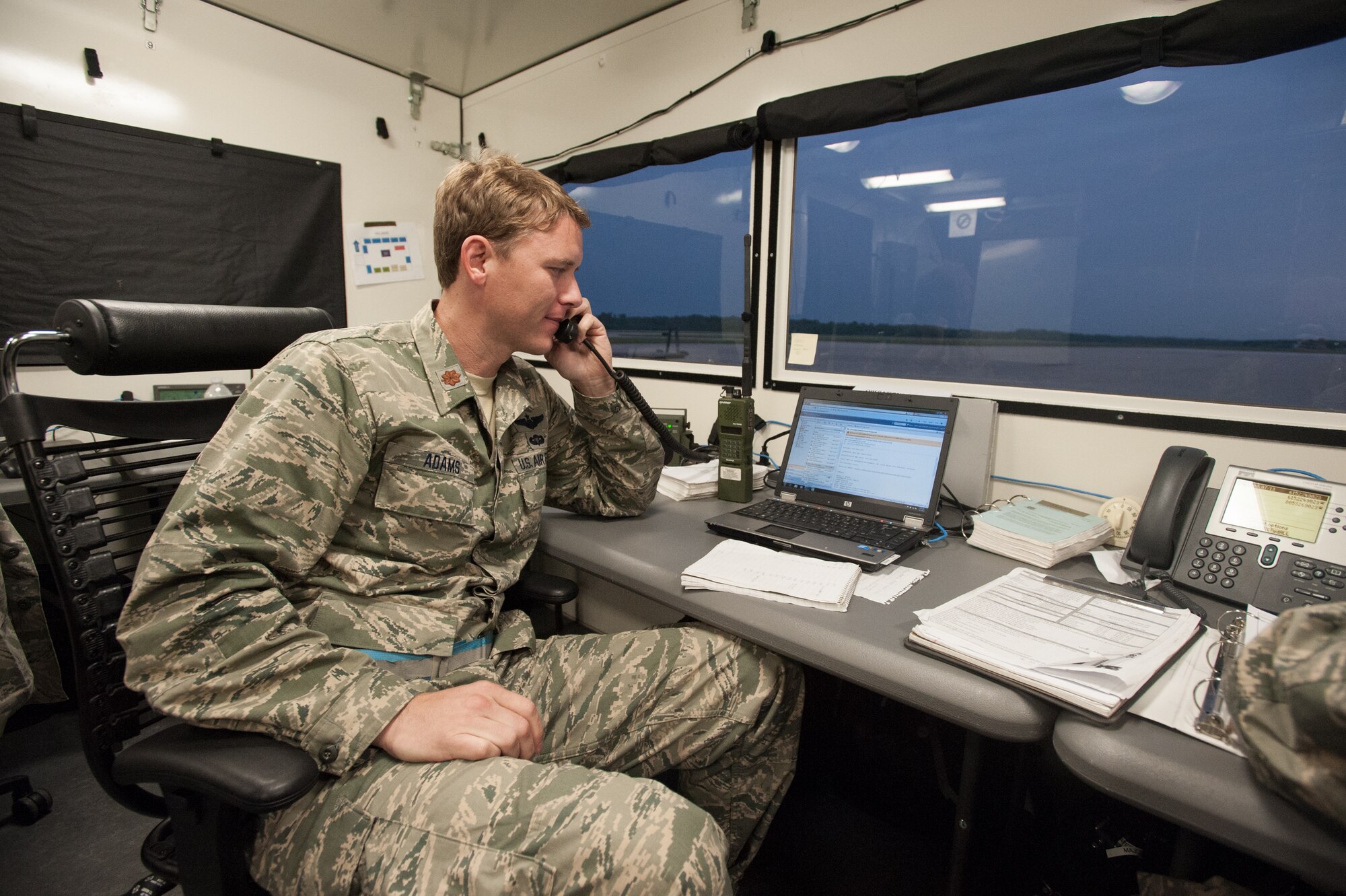 Maj. Ryan Adams, airflow operations officer for the Kentucky Air National Guard’s 123rd Contingency Response Group, coordinates with higher headquarters to control the airflow of simulated disaster-relief supplies into MidAmerica St. Louis Airport in Mascoutah, Ill., on Aug. 7, 2013, as part of Exercise Gateway Relief, a U.S. Transportation Command-directed earthquake-response scenario. Adams was working in a portable structure called a HELAMS, which is short for Hard-sided Expandable Lightweight Air Mobile Shelter. (U.S. Air National Guard photo by Maj. Dale Greer)