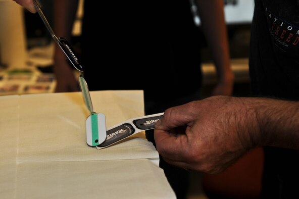 John Berry, 28th Force Support Squadron Arts and Crafts Skills Development Center recreation assistant, uses a heat press machine to transfer personalized images onto dog tags at the Arts and Crafts Center on Ellsworth Air Force Base, S.D., Aug. 1, 2013. Berry created dog tags for participants of the Dakota Storm car show using the heat press which is capable of transferring images to multiple materials. (U.S. Air Force photo by Airman 1st Class Rebecca Imwalle/Released)