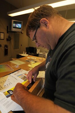 John Berry, 28th Force Support Squadron Arts and Crafts Skills Development Center recreation assistant, places a nametag on a coin holder during an engraving project at the Arts and Crafts Center on Ellsworth Air Force Base, S.D., Aug. 1, 2013. For more information on available services, contact the Arts and Crafts Center at 385-2899. (U.S. Air Force photo by Airman 1st Class Rebecca Imwalle/Released