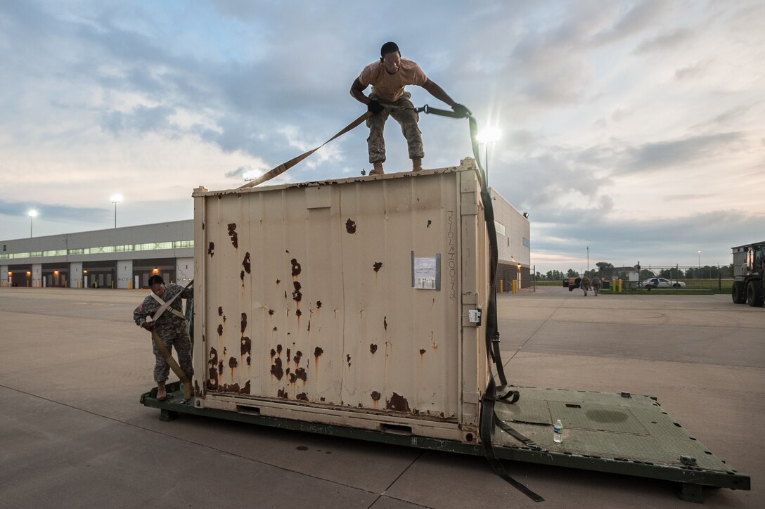 Army Pfc. Stephanie Solomon and Army Spc. Marquis Talbot of the U.S. Army’s 689th Rapid Port Opening Element in Fort Eustis, Va., strap simulated disaster-relief supplies to a flat-rack pallet on the flight line of MidAmerica St. Louis Airport in Mascoutah, Ill., on Aug. 7, 2013, as part of Exercise Gateway Relief, a U.S. Transportation Command-directed earthquake-response scenario. The 689th is joining with the Kentucky Air National Guard’s 123rd Contingency Response Group to stand up and operate a Joint Task Force-Port Opening through Aug. 9. The JTF-PO, which combines an Air Force Aerial Port of Debarkation with an Army trucking and distribution unit, ensures the smooth flow of relief supplies into affected areas by airlift and coordinates final distribution over land. (U.S. Air National Guard photo by Maj. Dale Greer)