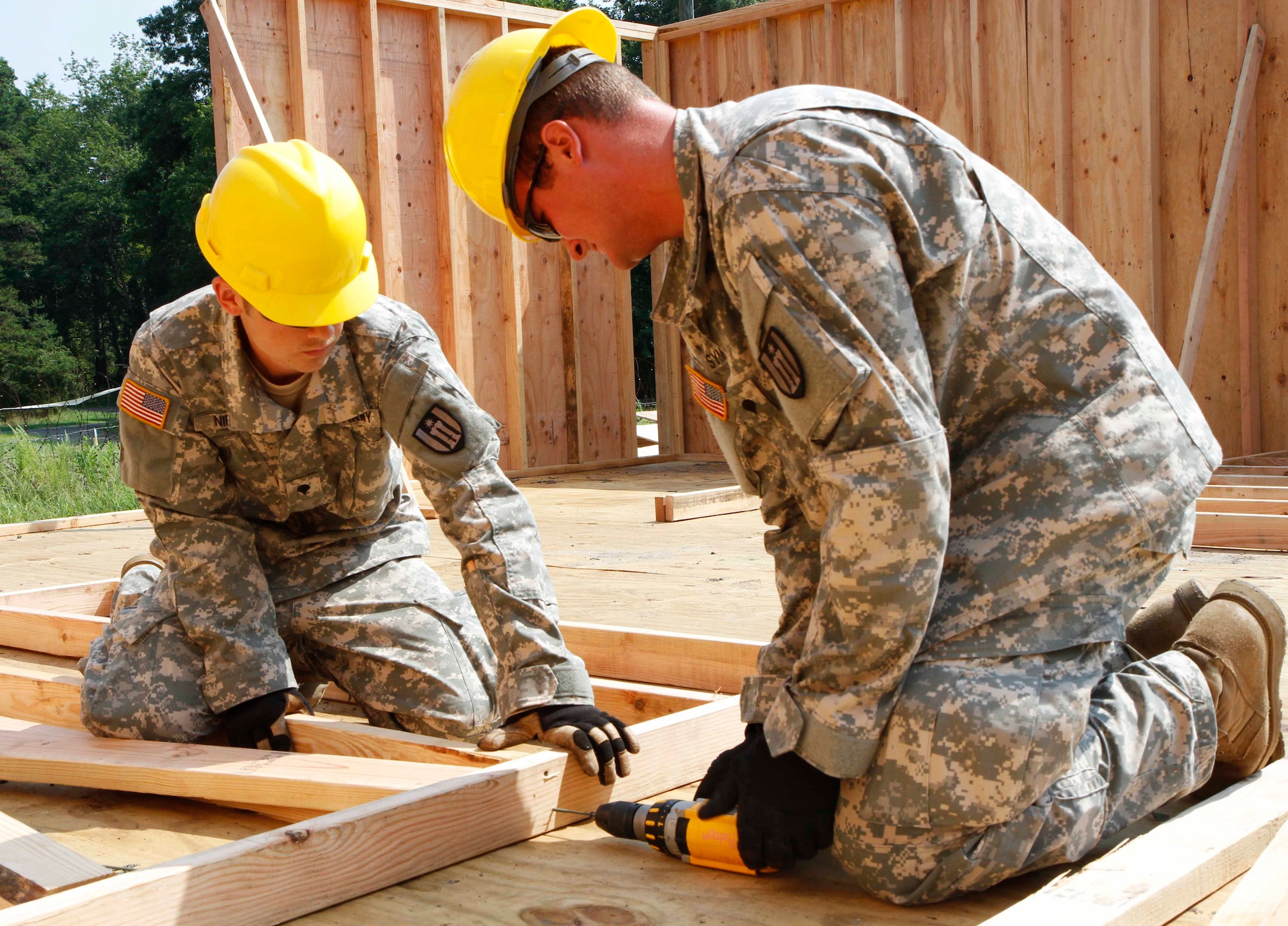 Army Spcs. James M. Nielsen and Spencer T. Symington, 461st Engineer Company interior electricians, work to complete a base frame for a building project during castle installation related construction at Joint Base McGuire-Dix-Lakehurst, N.J., July 19, 2013. (U.S. Army photo by Spc. True Thao/Released)