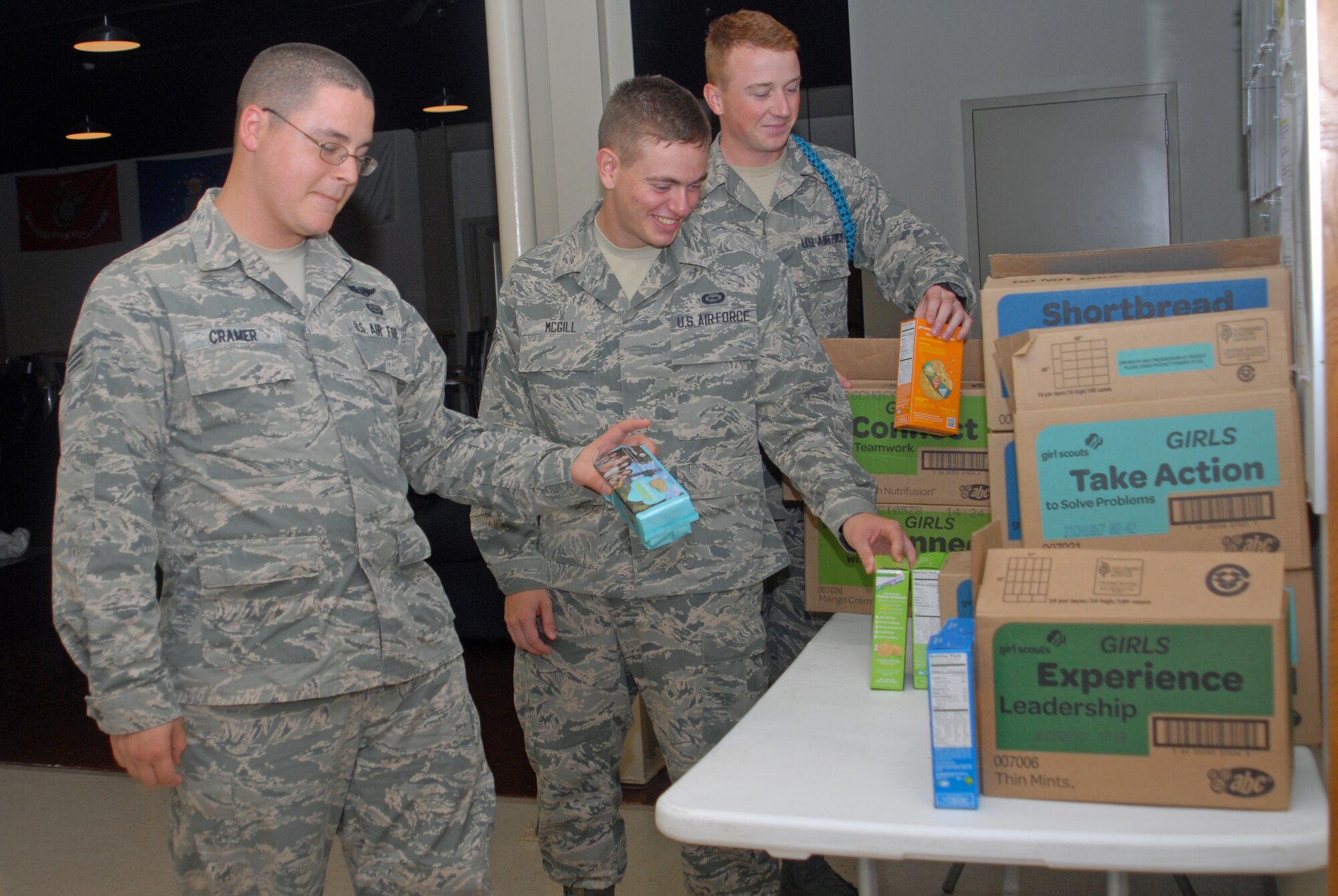 GOODFELLOW AIR FORCE BASE, Texas – Senior Airman Aaron Cramel, Airman 1st Class Colton McGill and Airman Patrick McGibnn, 316th Training Squadron students, pick which cookies they want at the Crossroads Student Ministry Center Aug. 6. Crossroads is a "sanctuary" for Soldiers, Marines, Sailors and Airmen to get away from the training environment. (U.S. Air Force photo/ Airman 1st Class Breonna Veal)