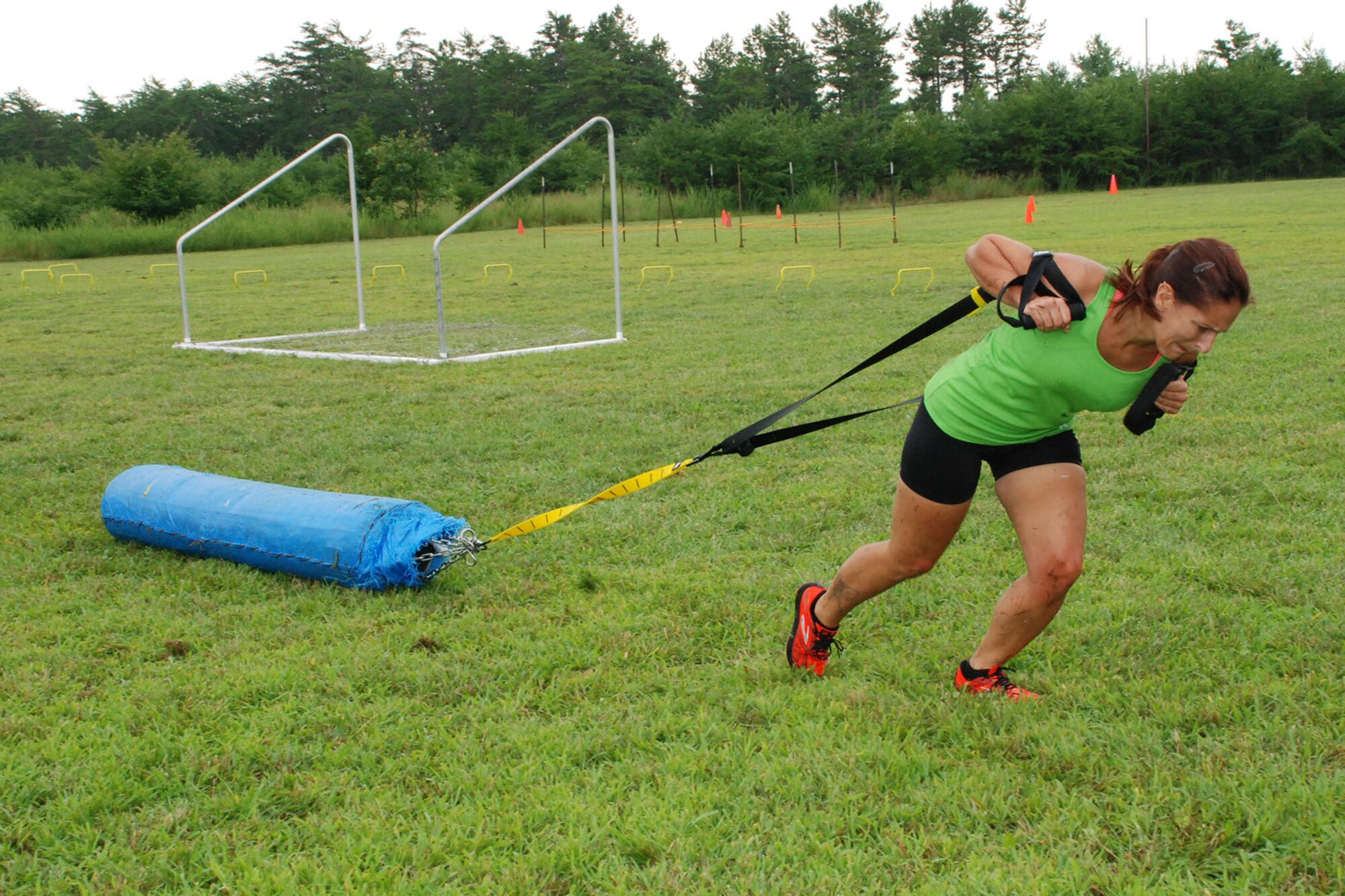 Christine Yezzo, Lakehurst community member, drags a heavy bag during the Dog Days of Summer Obstacle Course Challenge Aug. 1, 2013, at Joint Base McGuire-Dix-Lakehurst, N.J. Obstacles included jumping over a row of cement vehicle barricades, low crawling, flipping tractor tires, tossing a heavy ball, running with two weighted ammunition boxes, running zigzags and running through hula hoops, dragging a heavy object 25 yards.  (U.S. Navy photo by Lawrence Lyford/Released)