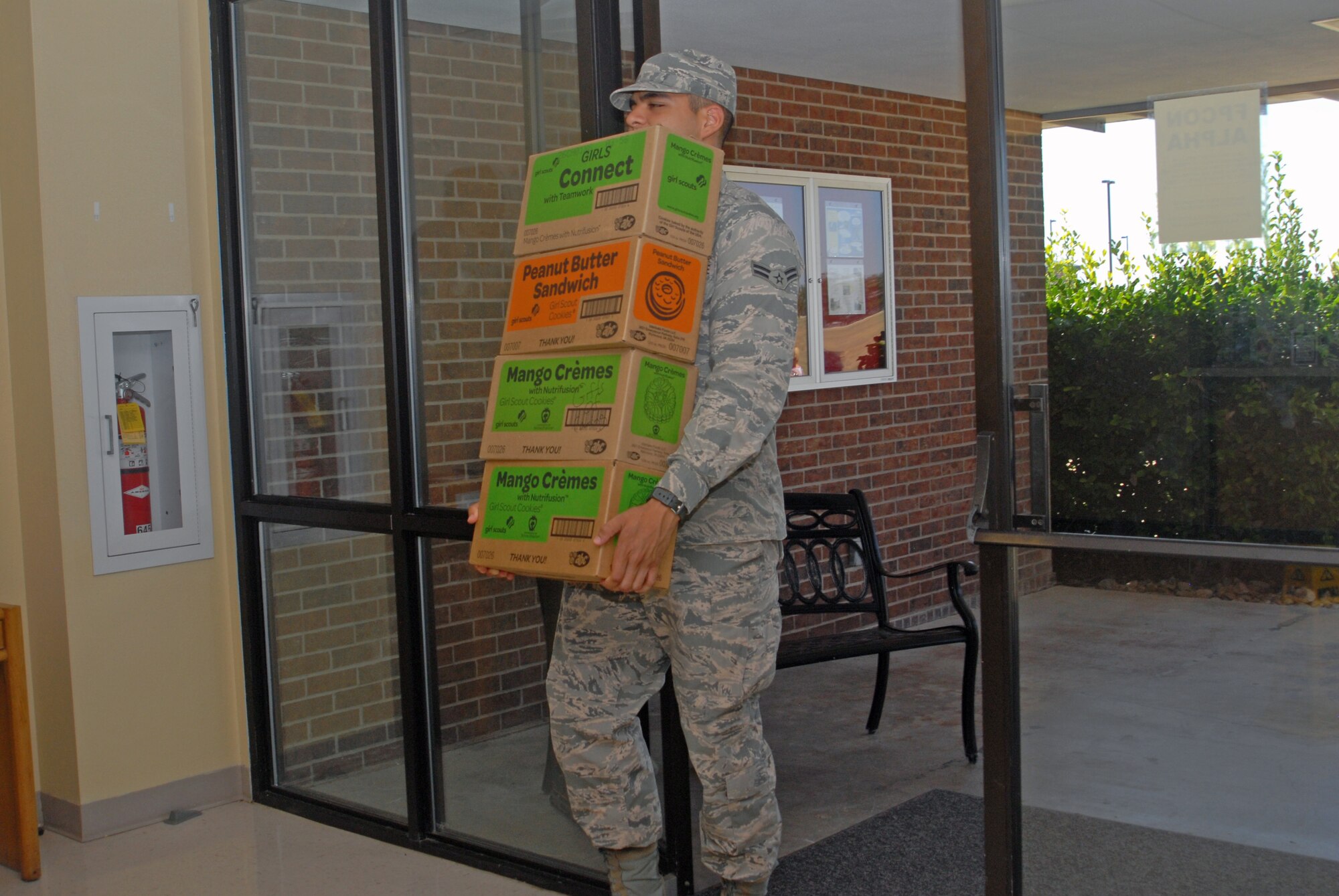 An Airman carries cases of Girl Scout cookies donated to the Crossroads Student Ministry Center Aug. 6. The San Angelo community donated cookies to students who come to the Crossroads. (U.S. Air Force photo/ Airman 1st Class Breonna Veal)