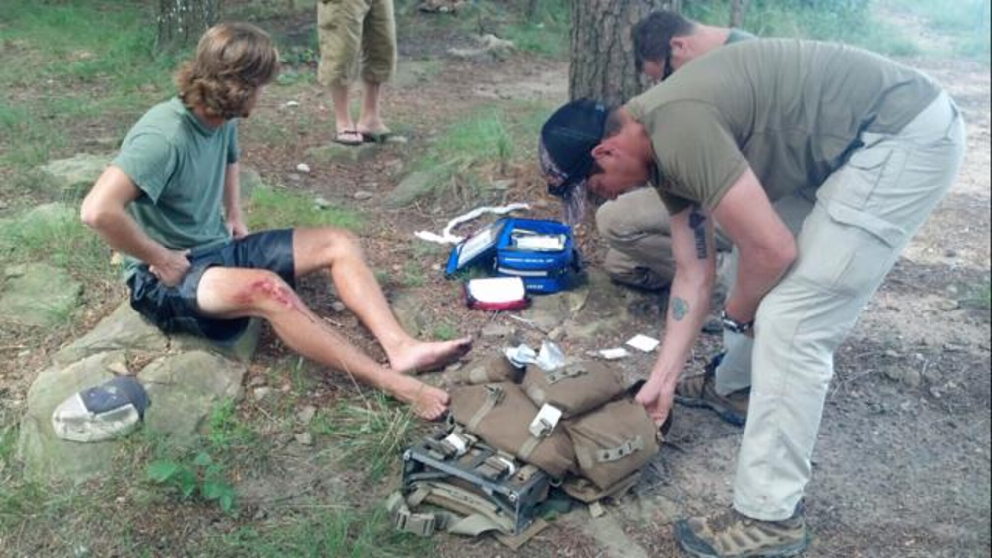 Staff Sgt. Matthew Macella and Staff Sgt. Chris Johnston, special tactics pararescuemen with the 24th Special Operations Wing, Hurlburt Field, Fla., provide medical aid to an Alabama teenager who fell 30 feet while rock climbing August 5, 2013. (courtesy photo)