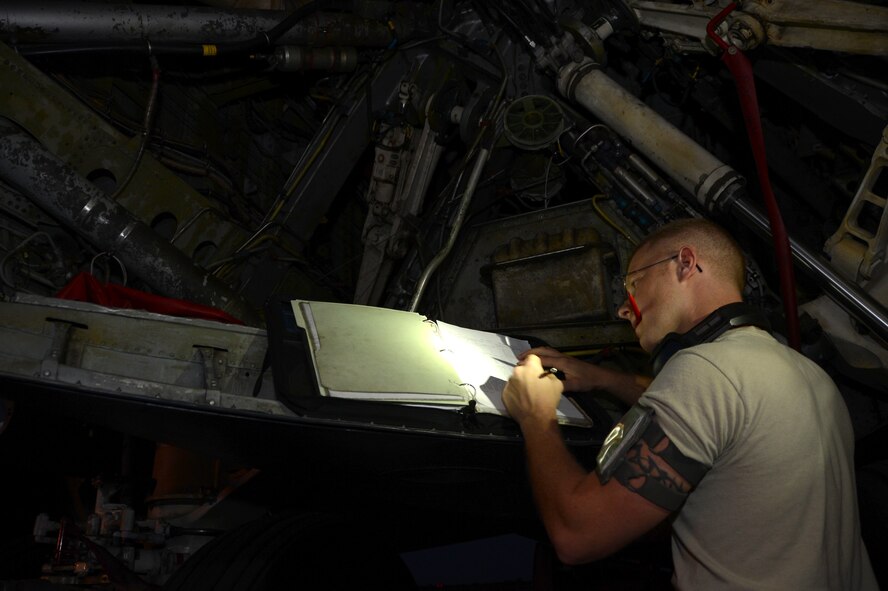 Staff Sgt. Benjamin Rose, 2nd Maintenance Squadron egress systems journeyman, fills out aircraft forms on the flightline at Barksdale Air Force Base, La., Aug. 5, 2013. When maintenance cannot be completed during the day, shift workers take on the task to complete the work, enabling the B-52H Stratofortress to be flight ready again as soon as possible. (U.S. Air Force photo/Staff Sgt. Amber Corcoran)