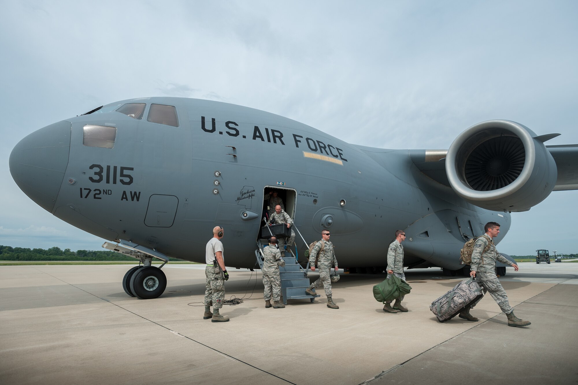 Members of the Kentucky Air National Guard’s 123rd Contingency Response Group arrive at MidAmerica St. Louis Airport in Mascoutah, Ill., on Aug. 6, 2013, after deploying from Louisville, Ky., aboard a Mississippi Air National Guard C-17 from the 172nd Airlift Wing. The Airmen are joining with Soldiers assigned to the U.S. Army’s active-duty 689th Rapid Port Opening Element from Fort Eustis, Va., to stand up and operate a Joint Task Force-Port Opening through Aug. 9 as part of a U.S. Transportation Command-directed earthquake-response scenario. A JTF-PO, which combines an Air Force Aerial Port of Debarkation with an Army trucking and distribution unit, ensures the smooth flow of relief supplies into affected areas by airlift, and coordinates their final distribution over land. (U.S. Air National Guard photo by Maj. Dale Greer)