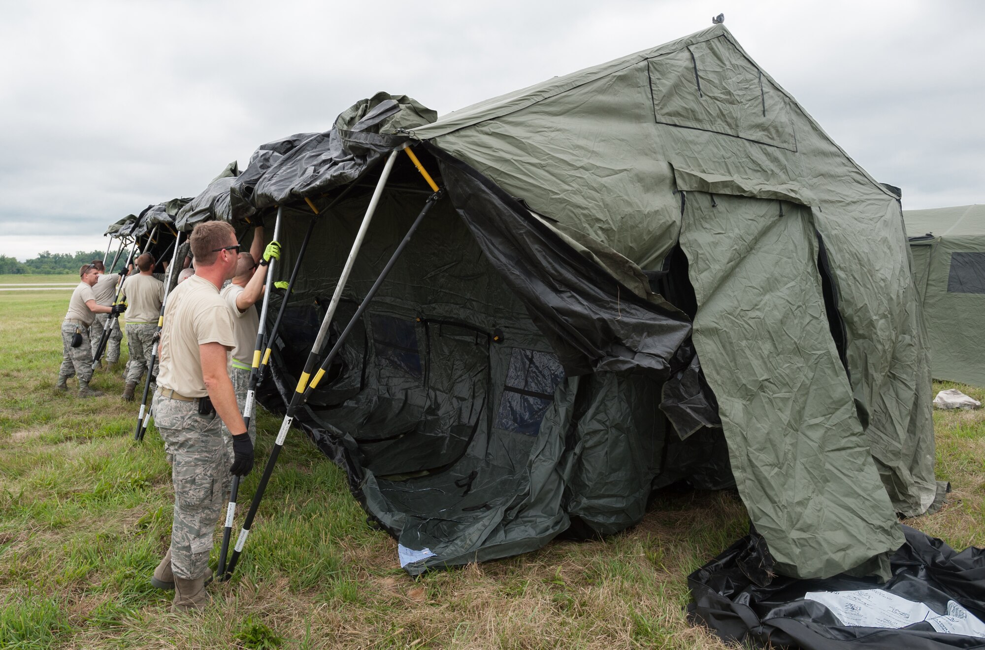 Airmen from the Kentucky Air National Guard’s 123rd Contingency Response Group and Soldiers from the U.S. Army’s active-duty 689th Rapid Port Opening Element from Fort Eustis, Va., erect a tent at MidAmerica St. Louis Airport in Mascoutah, Ill., on Aug. 5, 2013, as part of Exercise Gateway Relief, a U.S. Transportation Command-directed earthquake-response scenario. The two units are joining forces to stand up and operate a Joint Task Force-Port Opening, which combines an Air Force Aerial Port of Debarkation with an Army trucking and distribution unit. The aerial port ensures the smooth flow of cargo and relief supplies into affected areas by airlift, while the trucking unit facilitates their final distribution over land. (U.S. Air National Guard photo by Maj. Dale Greer)