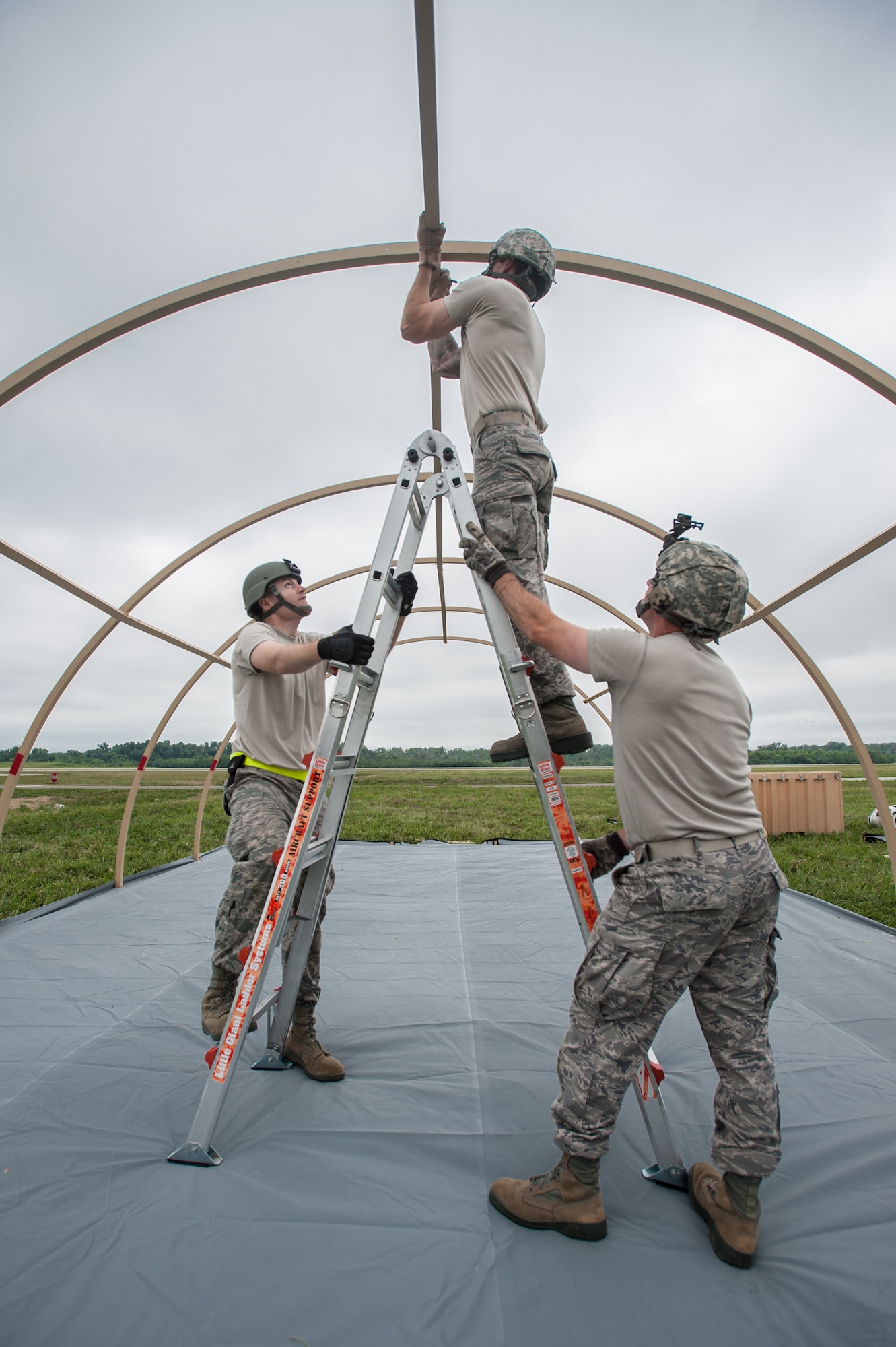 Airmen from the Kentucky Air National Guard’s 123rd Contingency Response Group and Soldiers from the U.S. Army’s active-duty 689th Rapid Port Opening Element from Fort Eustis, Va., erect Alaskan Shelter sleeping quarters at MidAmerica St. Louis Airport in Mascoutah, Ill., on Aug. 5, 2013, as part of Exercise Gateway Relief, a U.S. Transportation Command-directed earthquake-response scenario. The two units are joining forces to stand up and operate a Joint Task Force-Port Opening, which combines an Air Force Aerial Port of Debarkation with an Army trucking and distribution unit. The aerial port ensures the smooth flow of cargo and relief supplies into affected areas by airlift, while the trucking unit facilitates their final distribution over land. (U.S. Air National Guard photo by Maj. Dale Greer)
