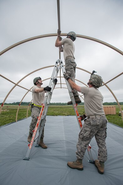 Airmen from the Kentucky Air National Guard’s 123rd Contingency Response Group and Soldiers from the U.S. Army’s active-duty 689th Rapid Port Opening Element from Fort Eustis, Va., erect Alaskan Shelter sleeping quarters at MidAmerica St. Louis Airport in Mascoutah, Ill., on Aug. 5, 2013, as part of Exercise Gateway Relief, a U.S. Transportation Command-directed earthquake-response scenario. The two units joined forces to stand up and operate a Joint Task Force-Port Opening, which combines an Air Force Aerial Port of Debarkation with an Army trucking and distribution unit. The aerial port ensures the smooth flow of cargo and relief supplies into affected areas by airlift, while the trucking unit facilitates their final distribution over land. (U.S. Air National Guard photo by Maj. Dale Greer)