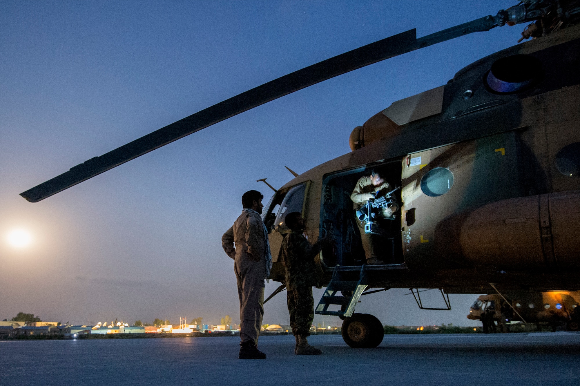 An Afghan Air Force aerial gunner readies the M240 machine gun on an Mi-17 helicopter under early morning moonlight at Jalalabad Airfield, Afghanistan, on the first day of Operation Seemorgh, July 23, 2013. Operation Seemorgh, named after a mythical bird, is the largest Afghan-led combat operation in more than 30 years, combining air and ground forces in an offensive focused on Taliban in Loghar Province. (U.S. Air Force Photo/Master Sgt. Ben Bloker)