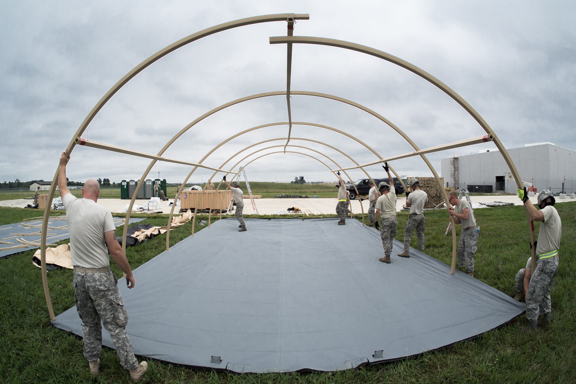 Airmen from the Kentucky Air National Guard’s 123rd Contingency Response Group and Soldiers from the U.S. Army’s active-duty 689th Rapid Port Opening Element from Fort Eustis, Va., erect Alaskan Shelter sleeping quarters at MidAmerica St. Louis Airport in Mascoutah, Ill., on Aug. 5, 2013, as part of Exercise Gateway Relief, a U.S. Transportation Command-directed earthquake-response scenario. The two units are joining forces to stand up and operate a Joint Task Force-Port Opening, which combines an Air Force Aerial Port of Debarkation with an Army trucking and distribution unit. The aerial port ensures the smooth flow of cargo and relief supplies into affected areas by airlift, while the trucking unit facilitates their final distribution over land. (U.S. Air National Guard photo by Maj. Dale Greer)