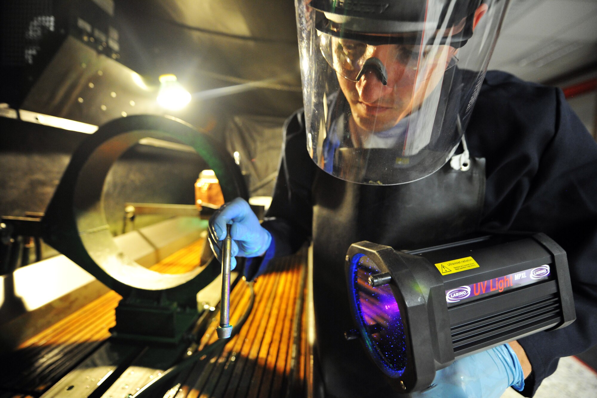 Staff Sgt. Joshua Paserba, 86th Maintenance Squadron nondestructive inspection technician, takes a closer look at a nose landing gear wheel bolt during a magnetic particle inspection, July 31, 2013, Ramstein Air Base, Germany.  Wheel bolts are inspected during tire overhauls to ensure the structural integrity of the bolt.  (U.S. Air Force photo/Senior Airman Chris Willis)