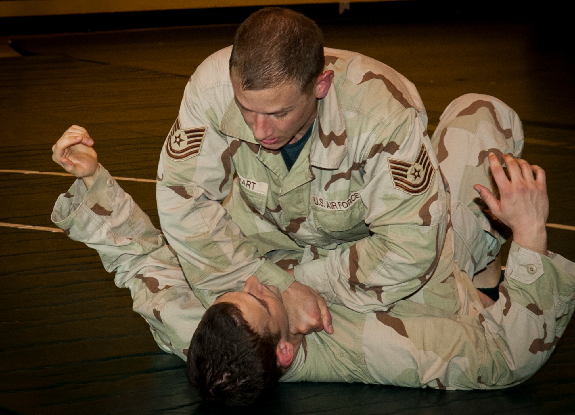 U.S. Air Force Staff Sgt. Christian Coleman, Misawa Combatives instructor, puts Senior Airman Scott Cross, Misawa Combatives participant, in a chokehold during combatives training at Misawa Air Base, Japan, July 30, 2013. The Misawa Combatives Program, led by Coleman, is transitioning into Level 2 where participants learn the why behind the moves they learned in Level 1. (U.S. Air Force photo by Airman 1st Class Zachary Kee)