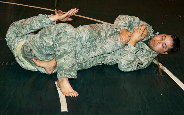 U.S. Air Force Tech. Sgt. Michael Osada, Misawa Combatives participant, puts Tech. Sgt. Chad Maglianes, Misawa Combatives participant, in a leg-lock during combatives training at Misawa Air Base, Japan, July 30, 2013. The Misawa Combatives Program teaches its participants different ways to attack an enemy combatant in hand-to-hand combat. (U.S. Air Force photo by Airman 1st Class Zachary Kee)