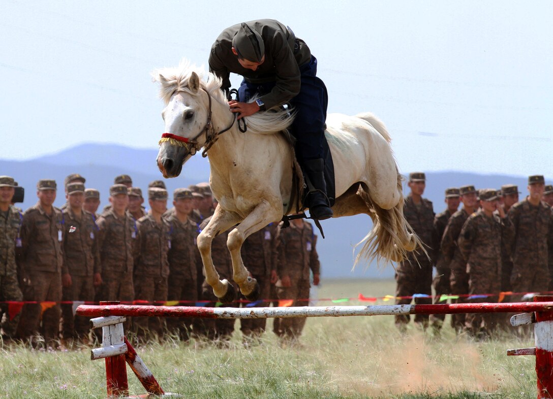 A Mongolian soldier jumps his horse during the opening ceremony for Khaan Quest 2013 at the Five Hills Training Area in Mongolia, Aug. 3, 2013.