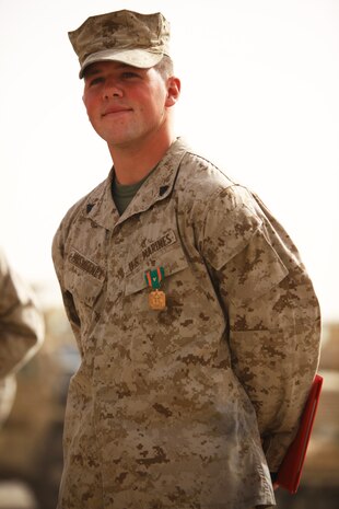 Cpl. Ryan T. McSweeney (right), a Middletown, Ohio, native and recovery vehicle operator with Transportation Support Company, Combat Logistics Regiment 2, Regional Command (Southwest), stands before his fellow servicemembers after receiving the Navy and Marine Corps Achievement Medal with Combat Distinguishing Device during an award ceremony at Camp Leatherneck, Afghanistan, July 23, 2013. McSweeney responded to the site of a suicide vehicle-borne improvised explosive device and helped repel an insurgent assault on Forward Operating Base Shir Ghazi in Helmand province, May 13, 2013. 