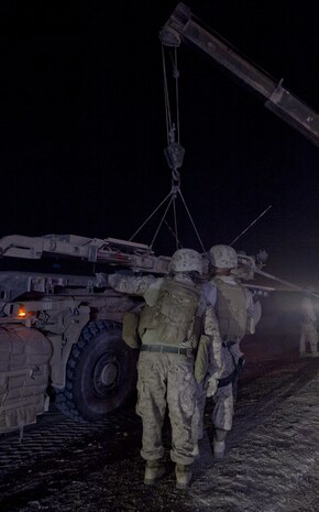 Marines with Combat Logistics Regiment 2, Regional Command (Southwest), prepare to hoist a damaged mine roller onto a truck during a recovery operation near Camp Leatherneck, Afghanistan, July 26, 2013. The Marines cordoned off the area to provide security for the recovery team as they rushed to clear the road before it interrupted local traffic patterns.