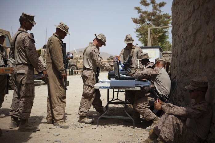 Marines line up to purchase items from Sgt. Arthur Doers, a native of Iron Mountain, Mich., and Marine Corps Community Services Marine with Combat Logistics Regiment 2, Regional Command (Southwest), at a forward operating base in Helmand province, Afghanistan, Aug. 4, 2013. Doers provided access to a mobile Post Exchange, which sold various hygiene, uniform and food commodities rarely seen by servicemembers operating at the isolated base. 