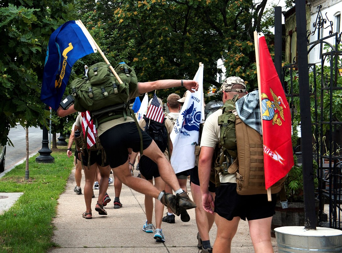 Senior Airman Tommy Allgier of “Delta Flight” from the 13th Air Support Operations Squadron, clicks his heels half way in of the final leg of their journey to honor a fallen commander Maj. David Gray, Aug. 8, 2013. The “DG” 140 is a 140-mile memorial ruck march from the Casualty Reception Center at Dover AFB to Maj. Gray’s headstone at Arlington National Cemetery in Virginia, Aug. 4-8. (U.S. Air Force photo/Senior Airman Carlin Leslie)