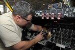 Tech. Sgt. John Kerschenheiter, an electrician with the 191st Maintenance Squadron connects wiring for a new antennae to the flight controls of a KC-135 Stratotanker at Selfridge Air National Guard Base, Mich., Jan. 30, 2013. The KC-135, assigned to the 127th Air Refueling Group of the Michigan Air National Guard, was being outfitted with the additional antennae to allow it to serve as a platform for testing a prototype of a new aircraft defense system.
